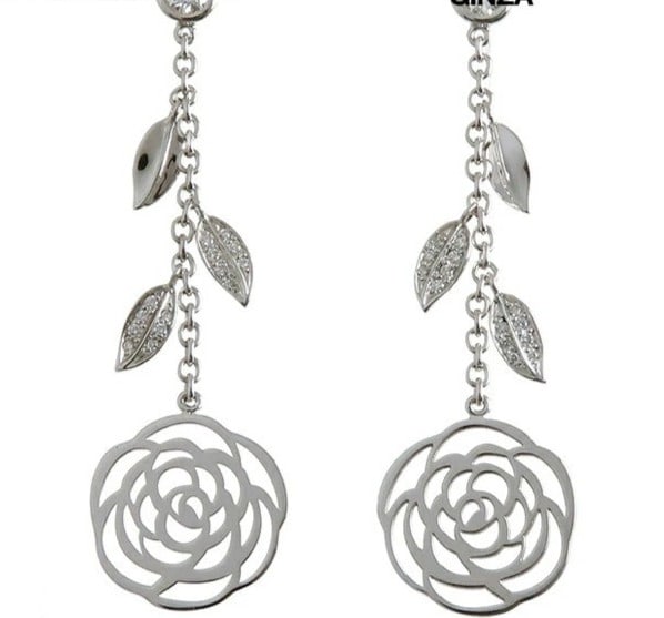 White gold diamond earring with camellia motif and original box from Chanel.: White gold diamond earring with camellia motif and original box from Chanel. Elevate your elegance with these exquisite 18k white gold earrings, adorned with a delicate camellia motif and featuring a