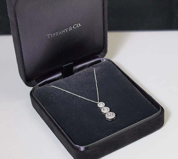 Tiffany & Co platinum necklace pendant with triple drop diamond circlet gift.: Tiffany & Co platinum necklace pendant with triple drop diamond circlet gift. Elevate your special occasion with the timeless elegance of Tiffany & Co.'s platinum necklace pendant, boasting a