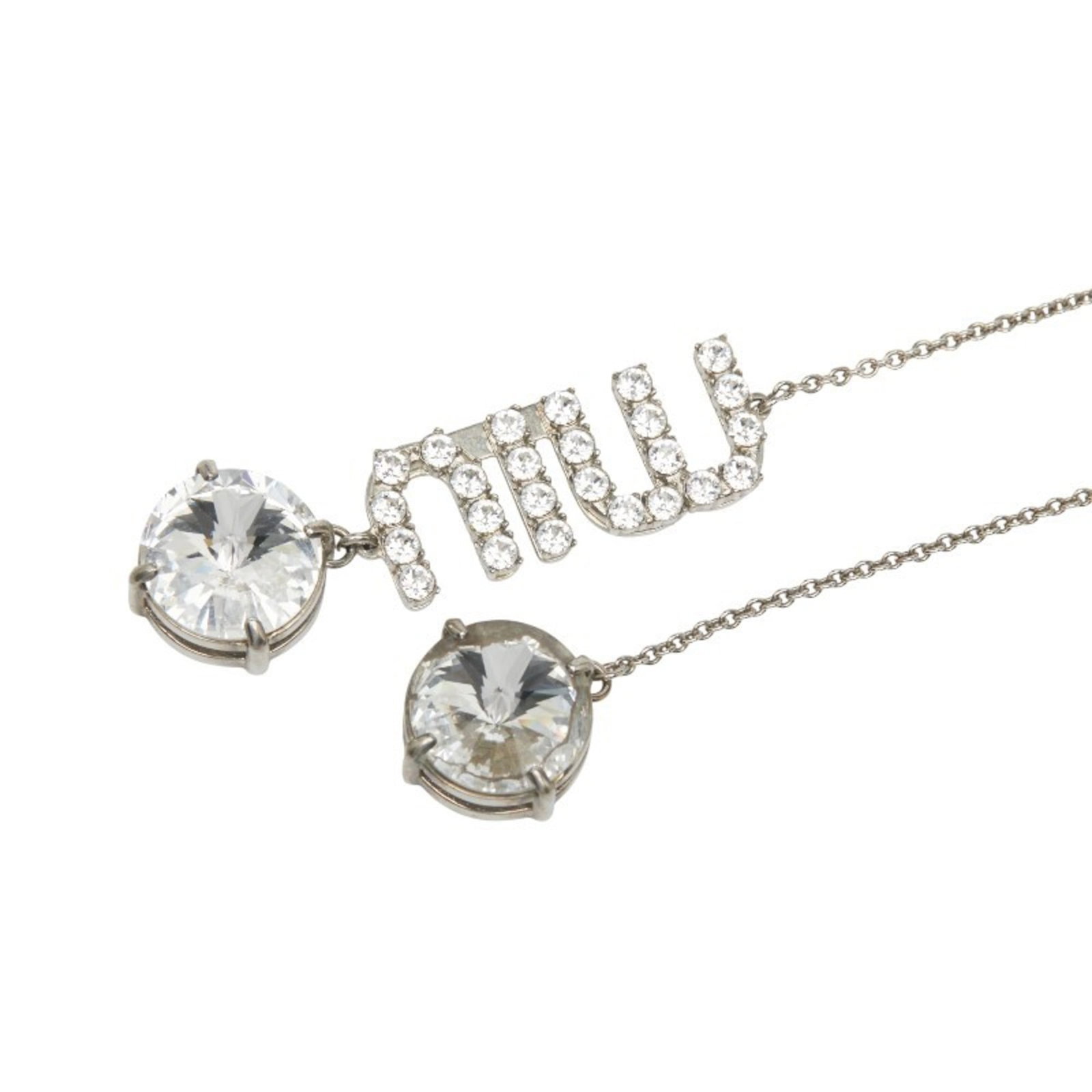 Silver metal rhinestone necklace for women Miu logo: Silver metal rhinestone necklace for women Miu logo Elevate your style with this stunning silver metal rhinestone necklace featuring the iconic Miu logo. The 111.5 cm chain is adorned with intricate