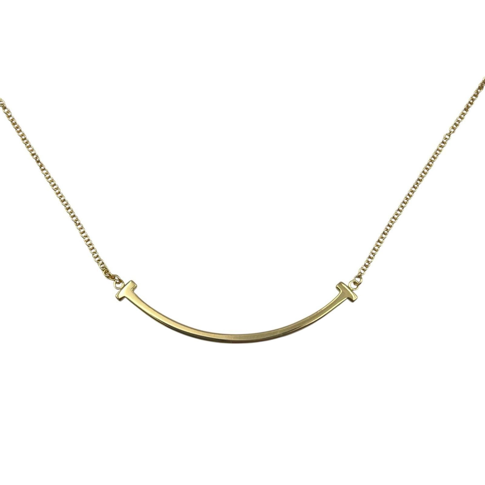 Women's 18K Yellow Gold Small Tiffany & Co. T Smile Pendant Necklace: Women's 18K Yellow Gold Small Tiffany & Co. T Smile Pendant Necklace A delicate 18K yellow gold Tiffany & Co. pendant necklace with the iconic T Smile design adds a touch of elegance to any outfit.