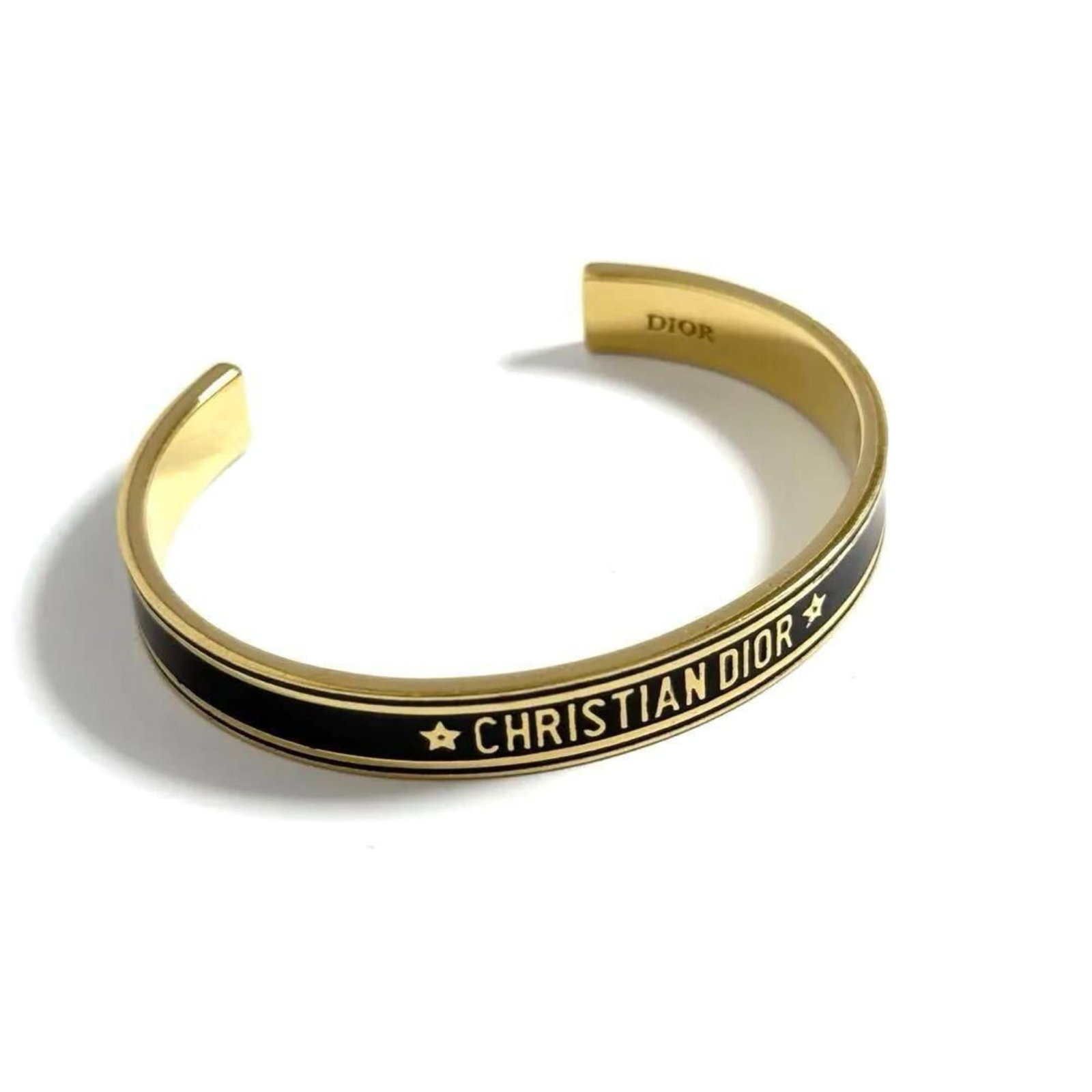 Christian Dior Metal Bangle: Christian Dior Metal Bangle A sleek and sophisticated metal bangle from Christian Dior adds a touch of elegance to any outfit with its understated yet refined design. Measuring 15.5cm in length, this
