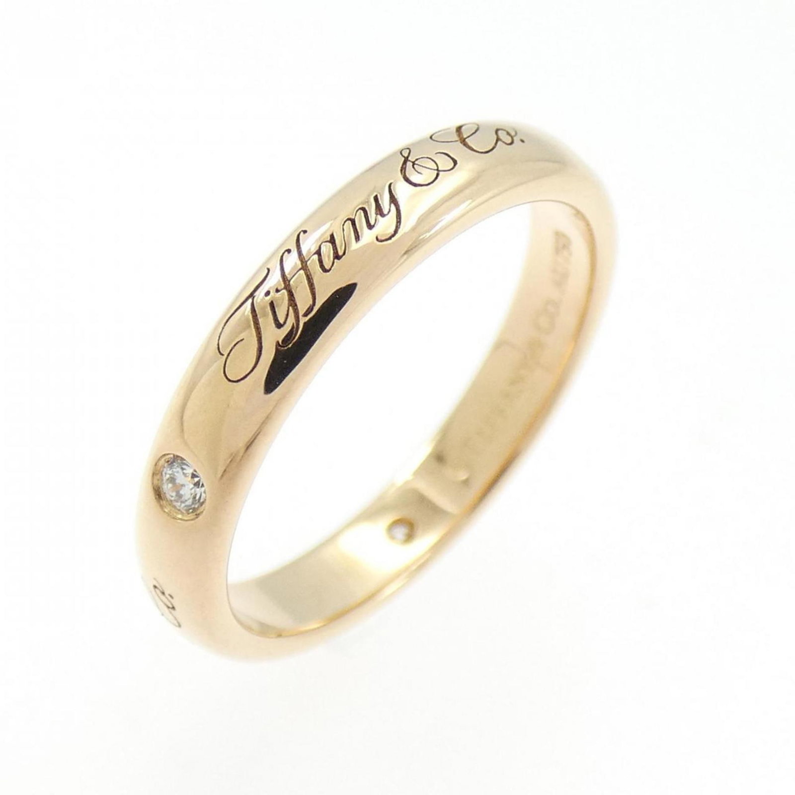 Pink gold 18k Tiffany band ring: Pink gold 18k Tiffany band ring A beautiful pink gold 18k Tiffany band ring, featuring a diamond stone, is up for auction. This used (very good) ring has some minor scratches and dirt, but remains in