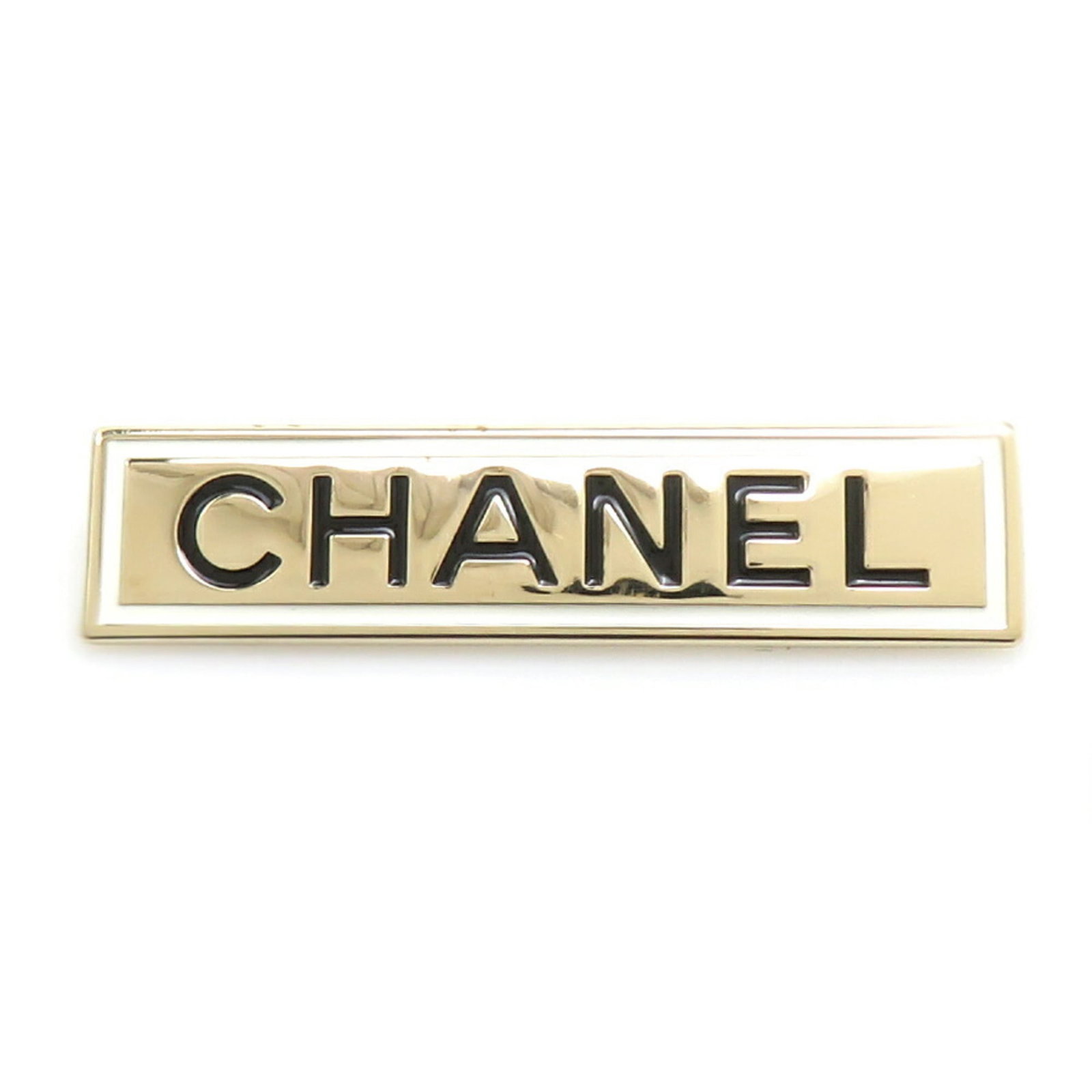 Metal Brooch By Chanel: Metal Brooch By Chanel A sleek metal brooch from the iconic French fashion house Chanel, this piece boasts a striking black and gold design with white accents. With its enamel and metal construction,