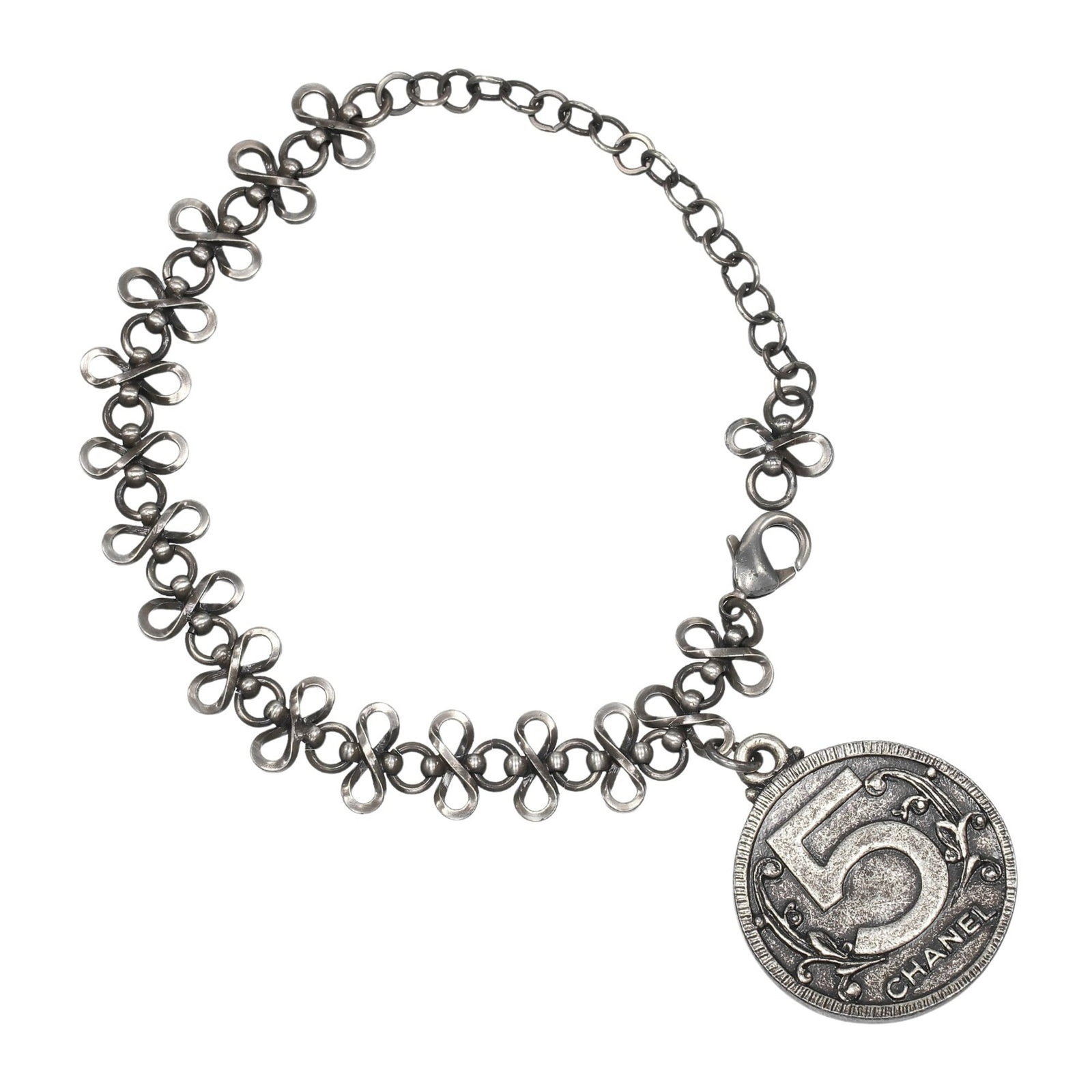 Chanel metal charm bracelet: Chanel metal charm bracelet A sleek and sophisticated silver metal charm bracelet from Chanel, featuring subtle signs of wear that add to its understated elegance. With a length of 23.8cm, this versat