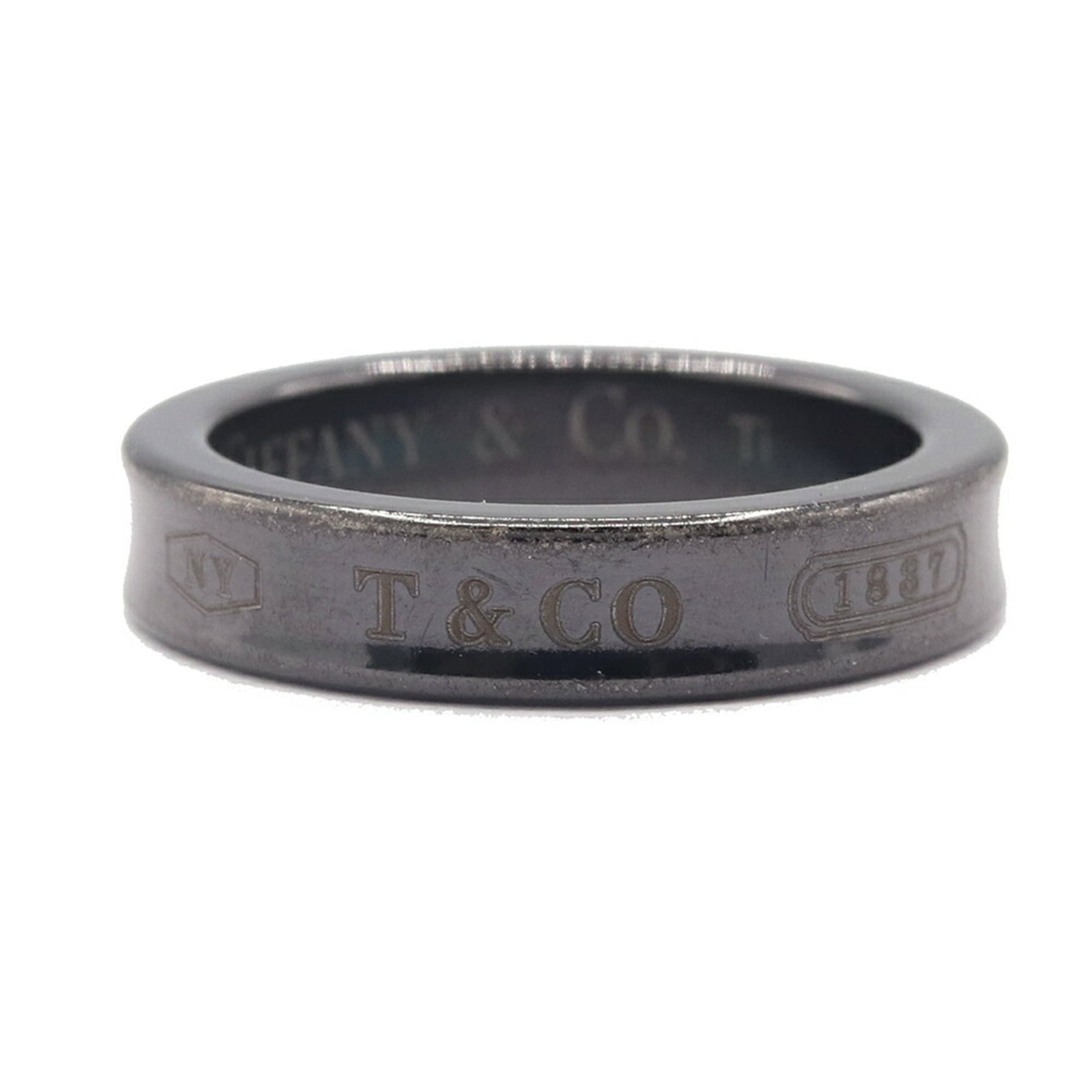 Titanium ring by Tiffany band.: Titanium ring by Tiffany band. A sleek and modern black titanium band from Tiffany & Co., this used ring boasts a durable 4mm width and weighs just 2.3g, making it a stylish accessory for everyday
