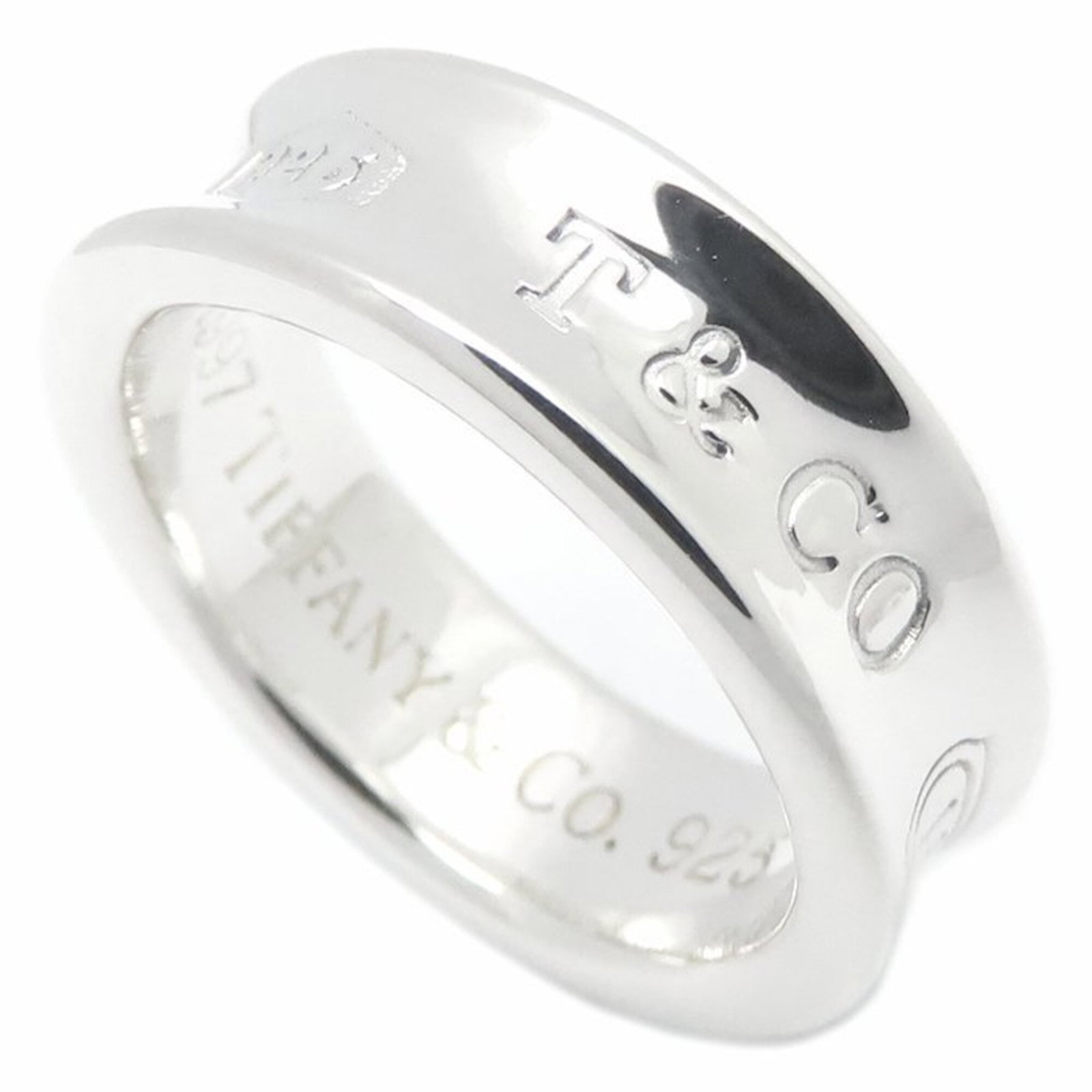 Tiffany Band Ring Silver 925: Tiffany Band Ring Silver 925 Silver 925 band ring from Tiffany features a classic design. The item has some minor scratches and dirt, with overall good condition despite being used. It measures 6.5 in