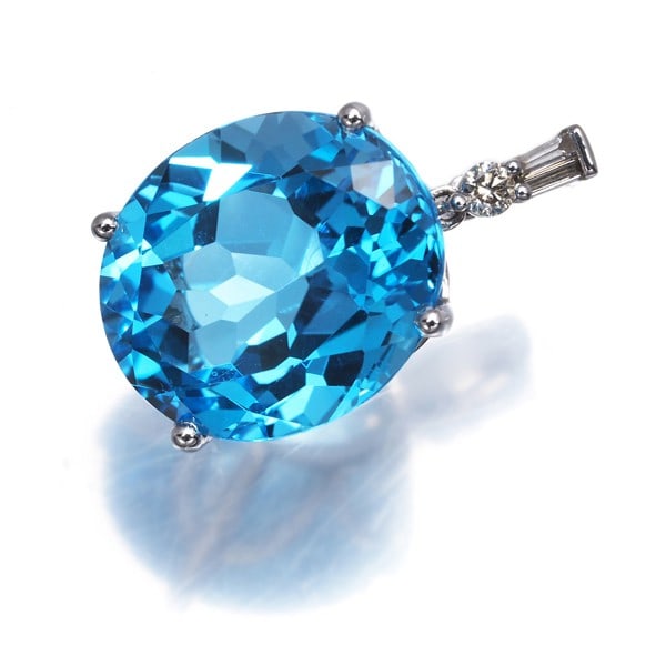 Diamond pendant 0.05ct in white gold: Diamond pendant 0.05ct in white gold The 0.05ct white gold diamond pendant features a natural topaz stone set in an 18k metal design, bearing a signature. This elegant piece showcases a subtle sparkle