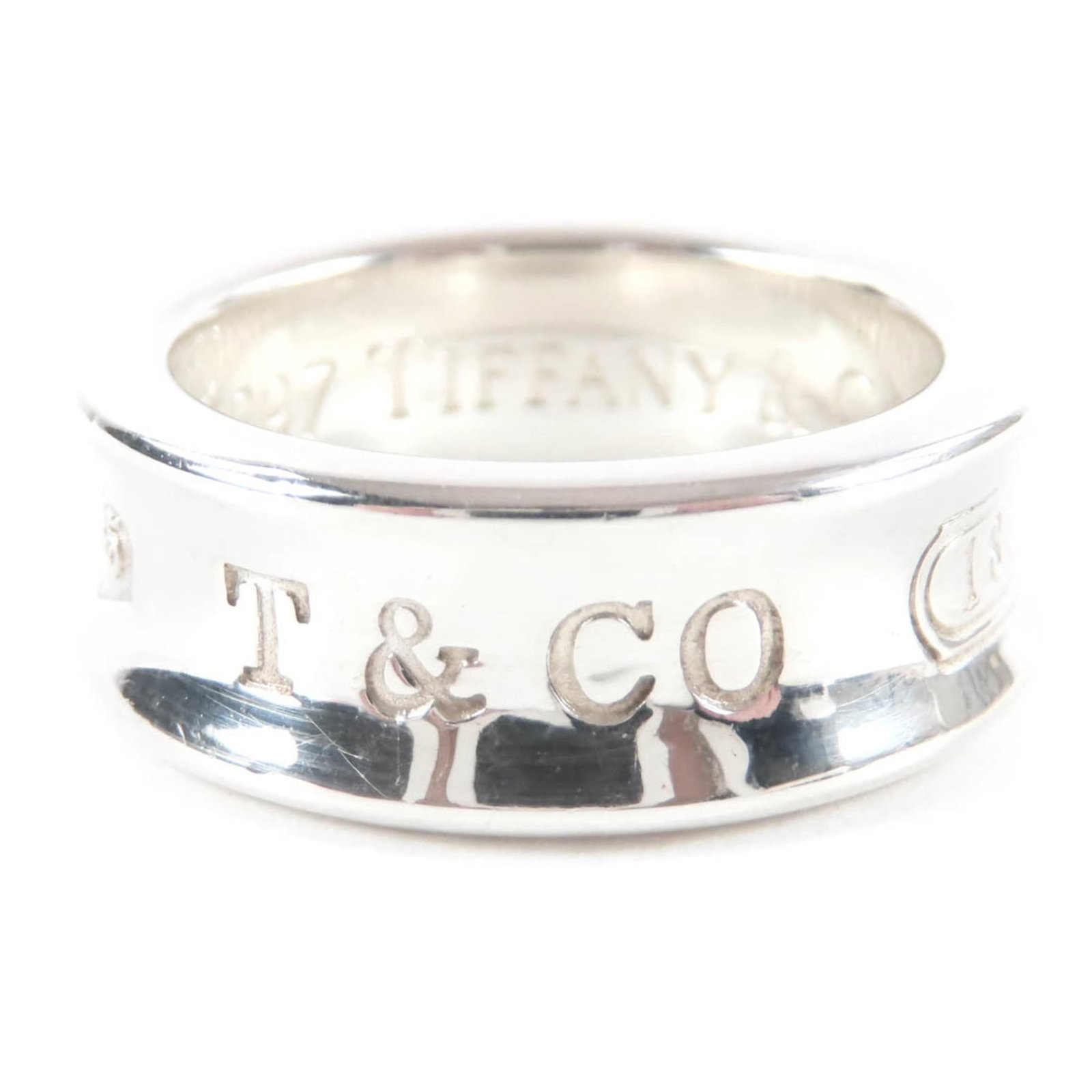 Tiffany Band Ring: Tiffany Band Ring This Tiffany band ring features a silver925 metal construction with a width of 5mm. Bearing a few traces of usage and minor scratches, the ring remains in very good condition despite