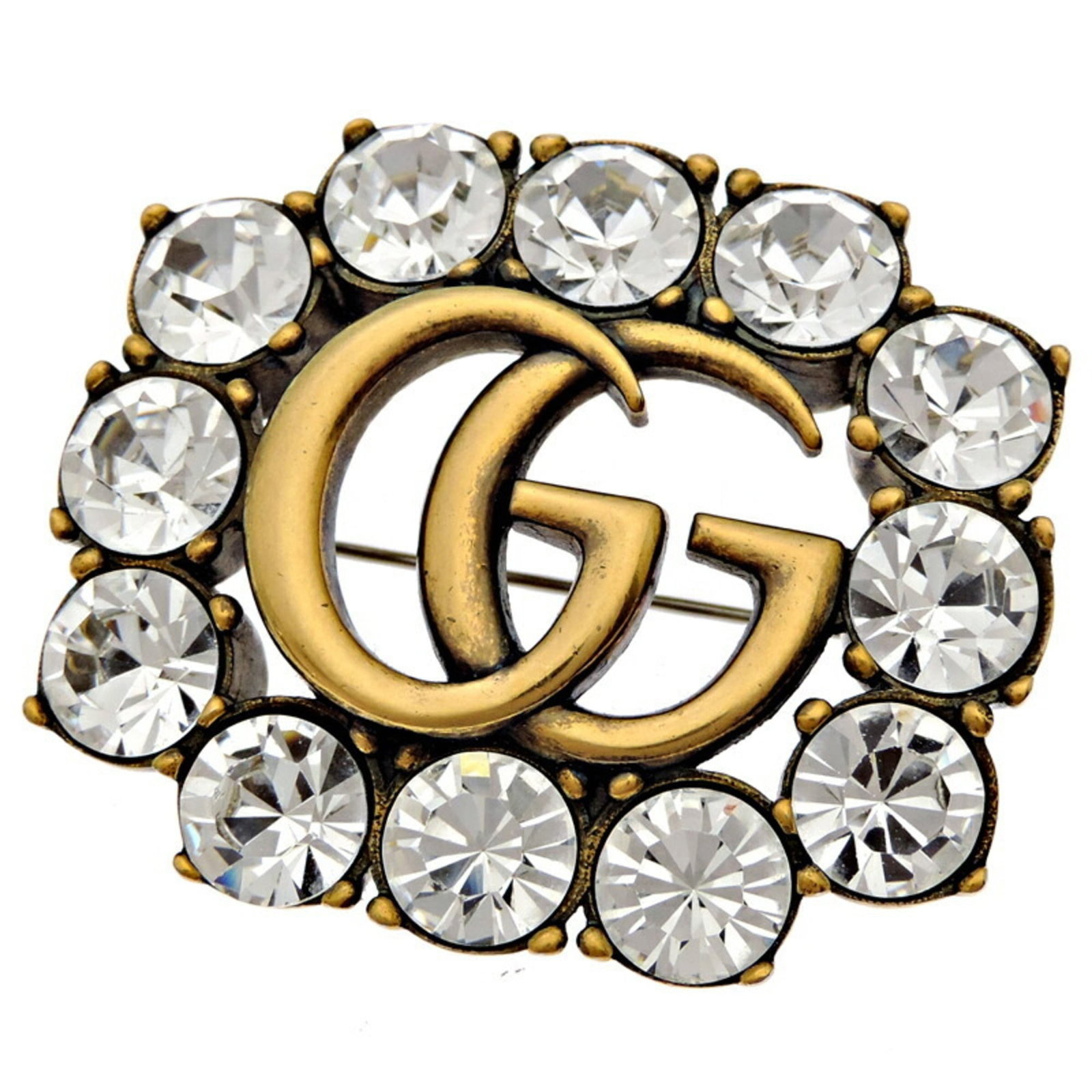 Gucci Brooch Metal: Gucci Brooch Metal The Gucci Brooch Metal features a sleek metal design with a notable brand logo. Traces of usage are visible, including scratches and dirt, indicating it has been worn before. The br