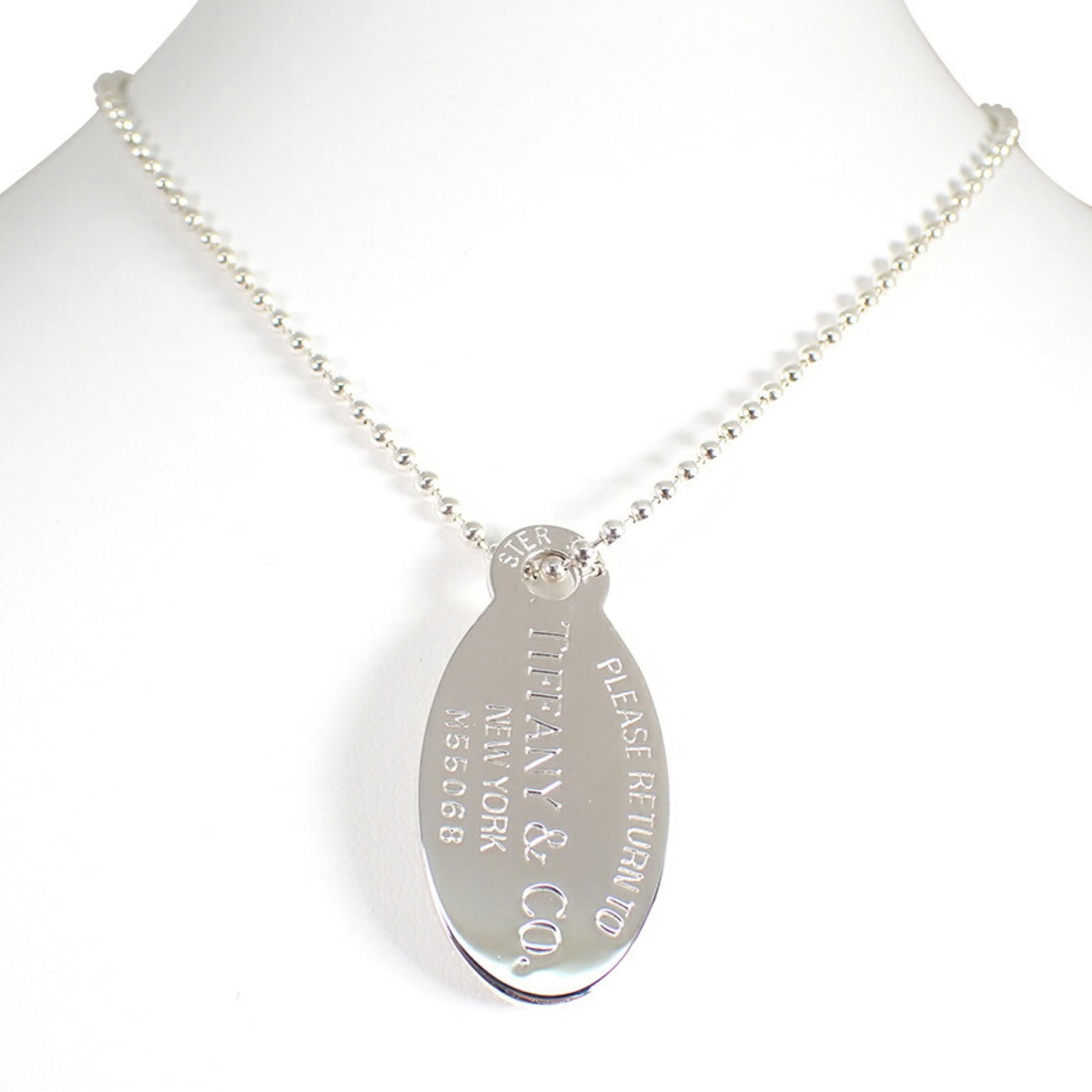 TIFFANY 925 Return to Tiffany Oval Tag Long Pendant: TIFFANY 925 Return to Tiffany Oval Tag Long Pendant Sterling silver necklace featuring an oval tag pendant from Tiffany & Co., with a 42mm x 20mm design and a 87cm chain circumference. The pendant its