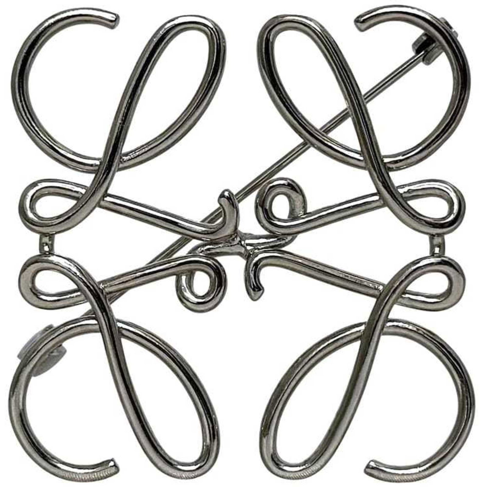 Loewe Pin Brooch Metal: Loewe Pin Brooch Metal This silver Loewe Pin Brooch Metal features a sleek design with a compact size of 5cm x 5cm. With a few traces of usage visible, this brooch still presents itself in very good