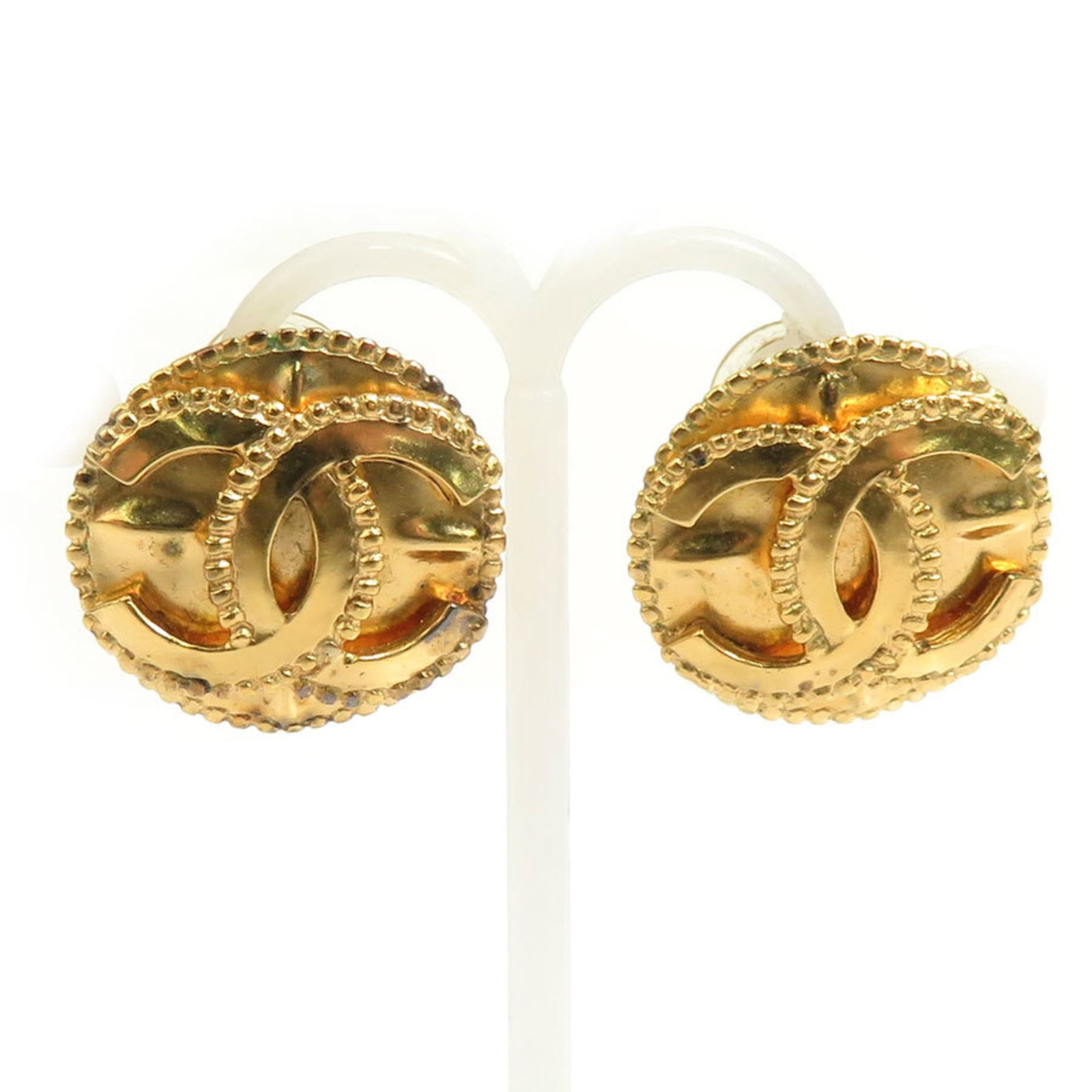 Chanel Clip Earrings Metal: Chanel Clip Earrings Metal Gold clip earrings from Chanel, featuring metal construction with visible traces of usage and minor scratches. The condition reflects typical wear, with some dirt present.