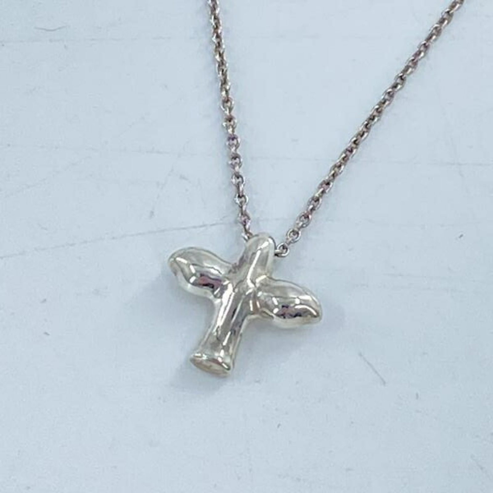 Tiffany & Co. Bird Cross Necklace, Silver, 925: Tiffany & Co. Bird Cross Necklace, Silver, 925 Tiffany & Co. Bird Cross Necklace in Silver 925 features a delicate 1mm x 1mm pendant with intricate details, showcasing the brand's iconic bird cross