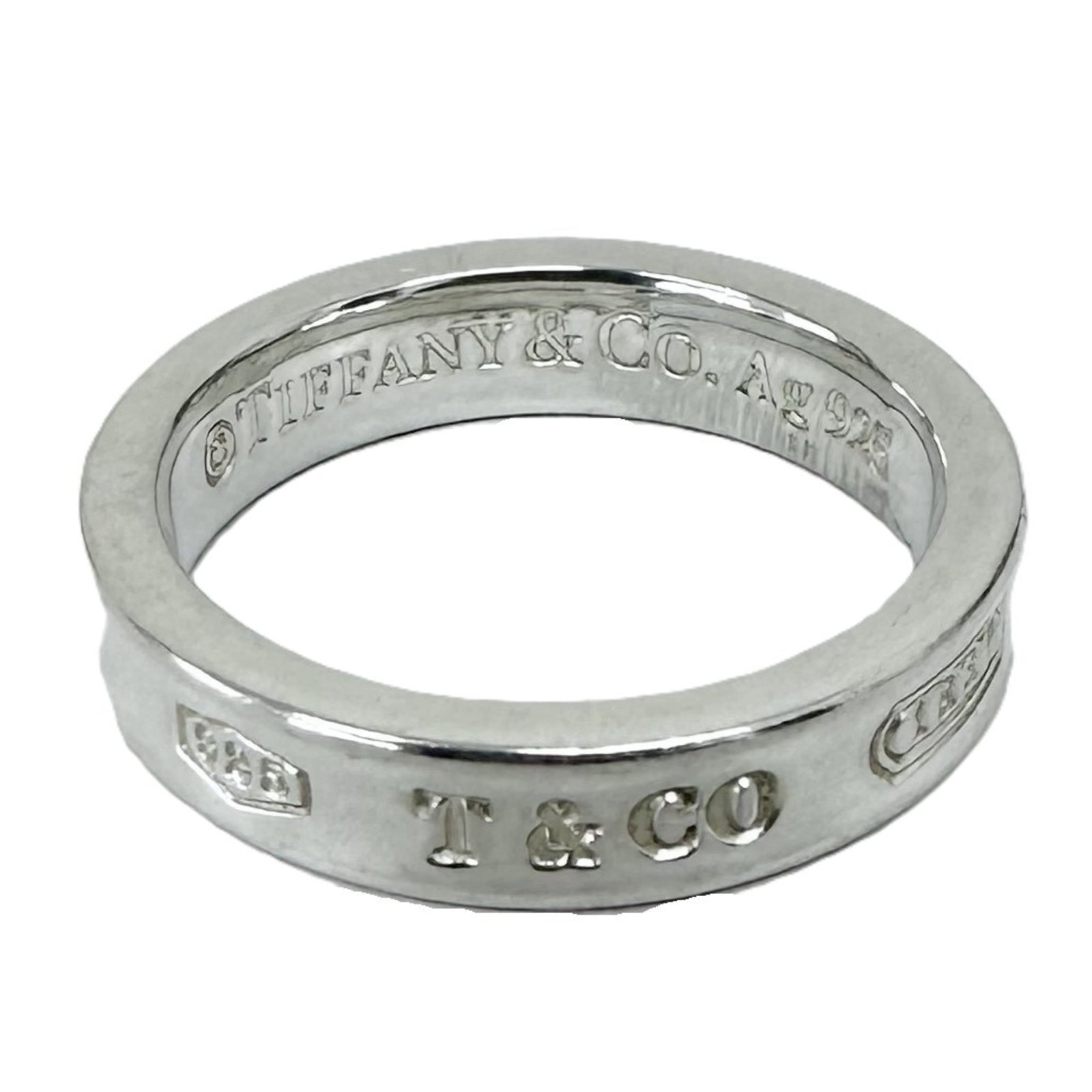 Tiffany Band Ring Silver 925: Tiffany Band Ring Silver 925 Silver 925 band ring from Tiffany, featuring a classic design with subtle wear and minor scratches. The ring's silver material gives it a sleek, modern look. In good condi