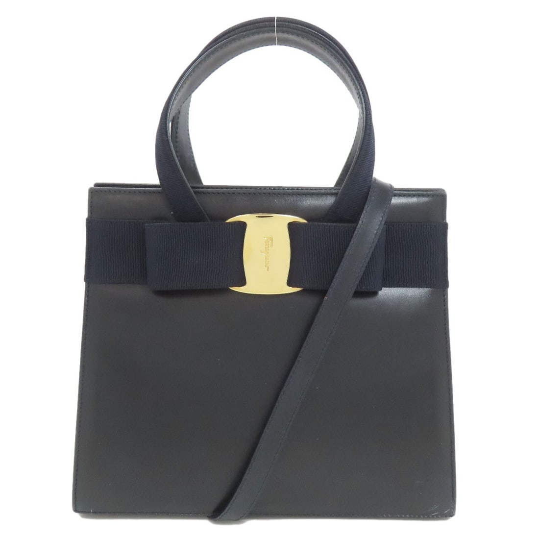 Ferragamo Leather Two Way Handbag Salva Ribbon Vala: Ferragamo Leather Two Way Handbag Salva Ribbon Vala Black leather two-way handbag with Salva Ribbon Vala design. This iconic Ferragamo style boasts sleek lines and luxurious materials, making it a tim