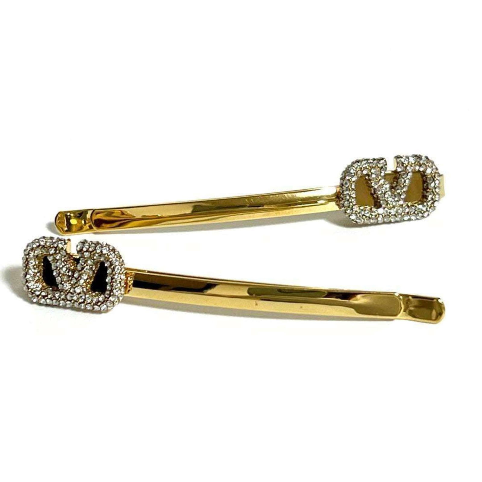 Valentino Hair Clip Metal Rhinestone: Valentino Hair Clip Metal Rhinestone Valentino's iconic hair clip shines with its metal and rhinestone design. The subtle scratches and minor dirt on this used item add to its unique character, making
