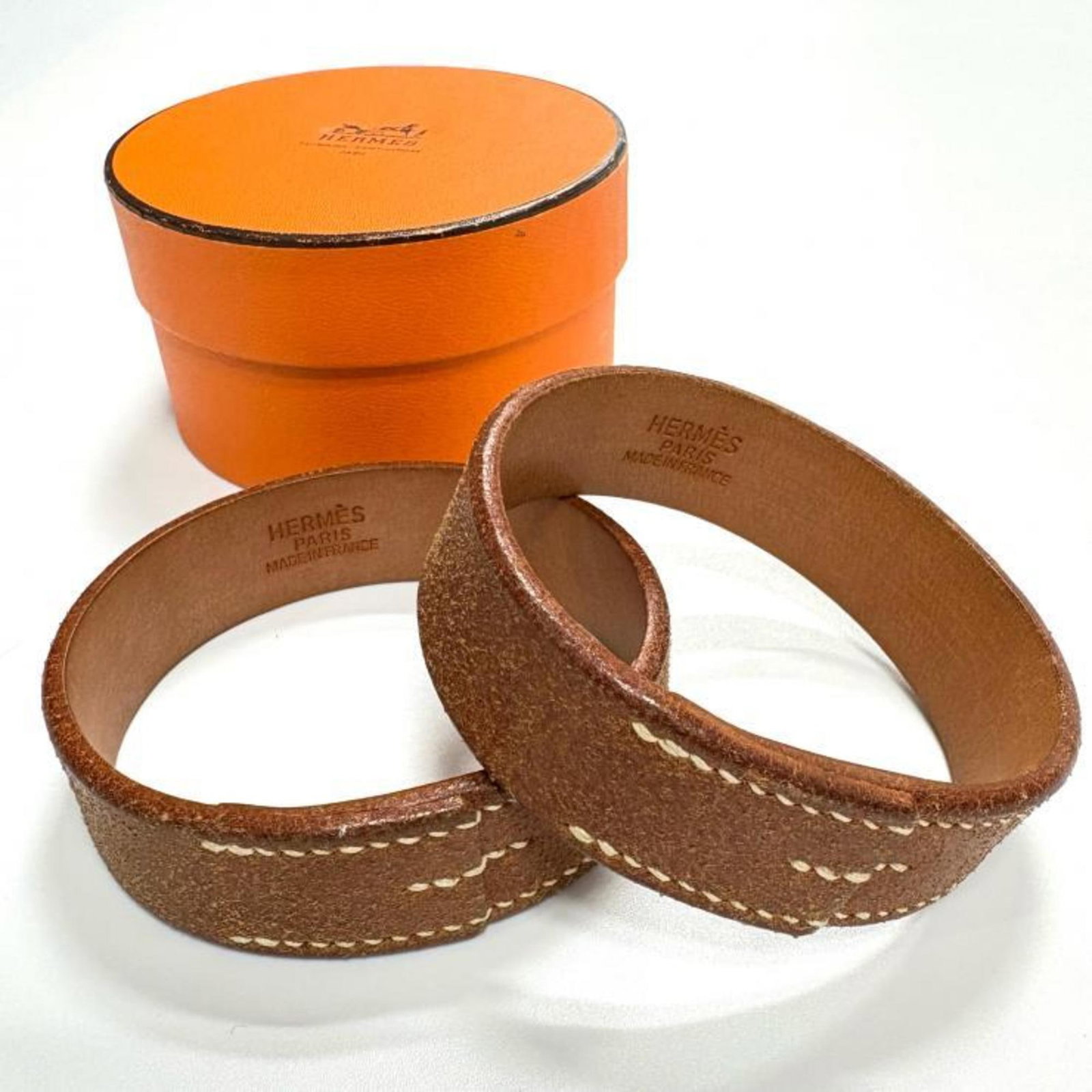 Hermes Bangle: Hermes Bangle The Hermes bangle boasts a rich brown hue and measures 22.2cm in length, making for a stylish accessory. With its understated design, this bangle showcases subtle signs of wear, includin