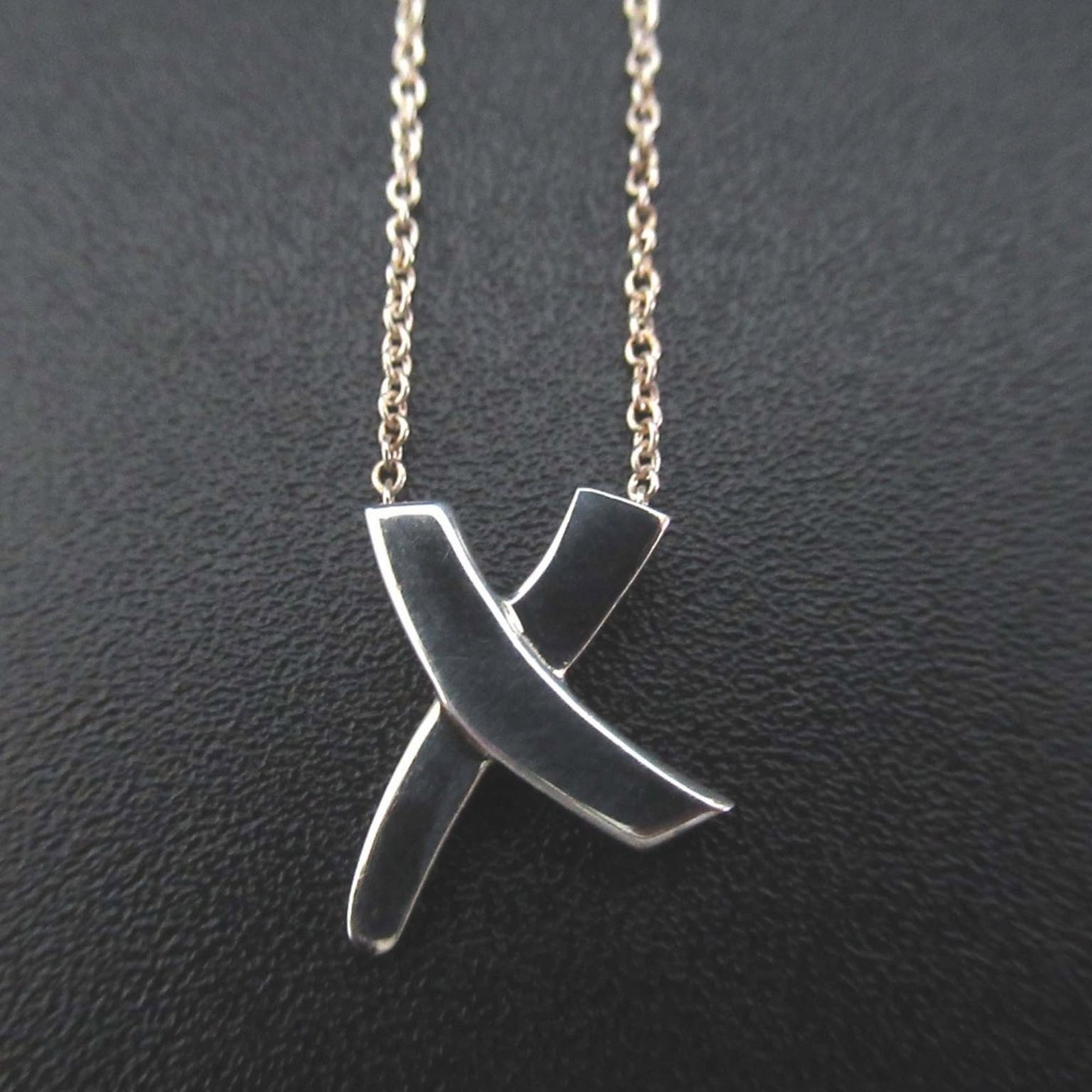 Tiffany & Co. Paloma Picasso Graffiti X Kiss Necklace Pendant In 925 Sv Silver For Women: Tiffany & Co. Paloma Picasso Graffiti X Kiss Necklace Pendant In 925 Sv Silver For Women Tiffany & Co.'s Paloma Picasso Graffiti X Kiss Necklace Pendant is a striking piece of jewelry featuring a