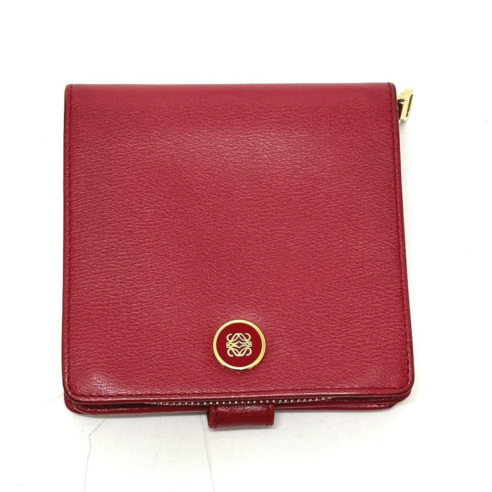 Loewe Wallet (Bi-Fold) Leather: Loewe Wallet (Bi-Fold) Leather This stunning Loewe bi-fold wallet features rich red leather and boasts a classic design. With its compact size and subtle scratches from previous use, this wallet exude
