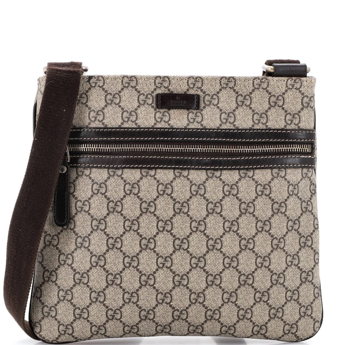 Front zip flat medium messenger bag: Front zip flat medium messenger bag Brown canvas coated medium messenger bag with front zip flat design. Features gold tone hardware and interior fabric, measuring 9" height x 10.5" width x 2" depth.