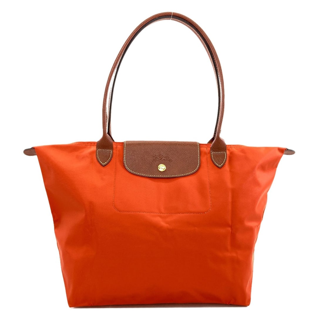 Nylon tote bag from Le Pliage: Nylon tote bag from Le Pliage Nylon tote bag from Le Pliage in vibrant orange. Made with durable nylon exterior, this Longchamp style tote bag offers a stylish and practical way to carry everyday