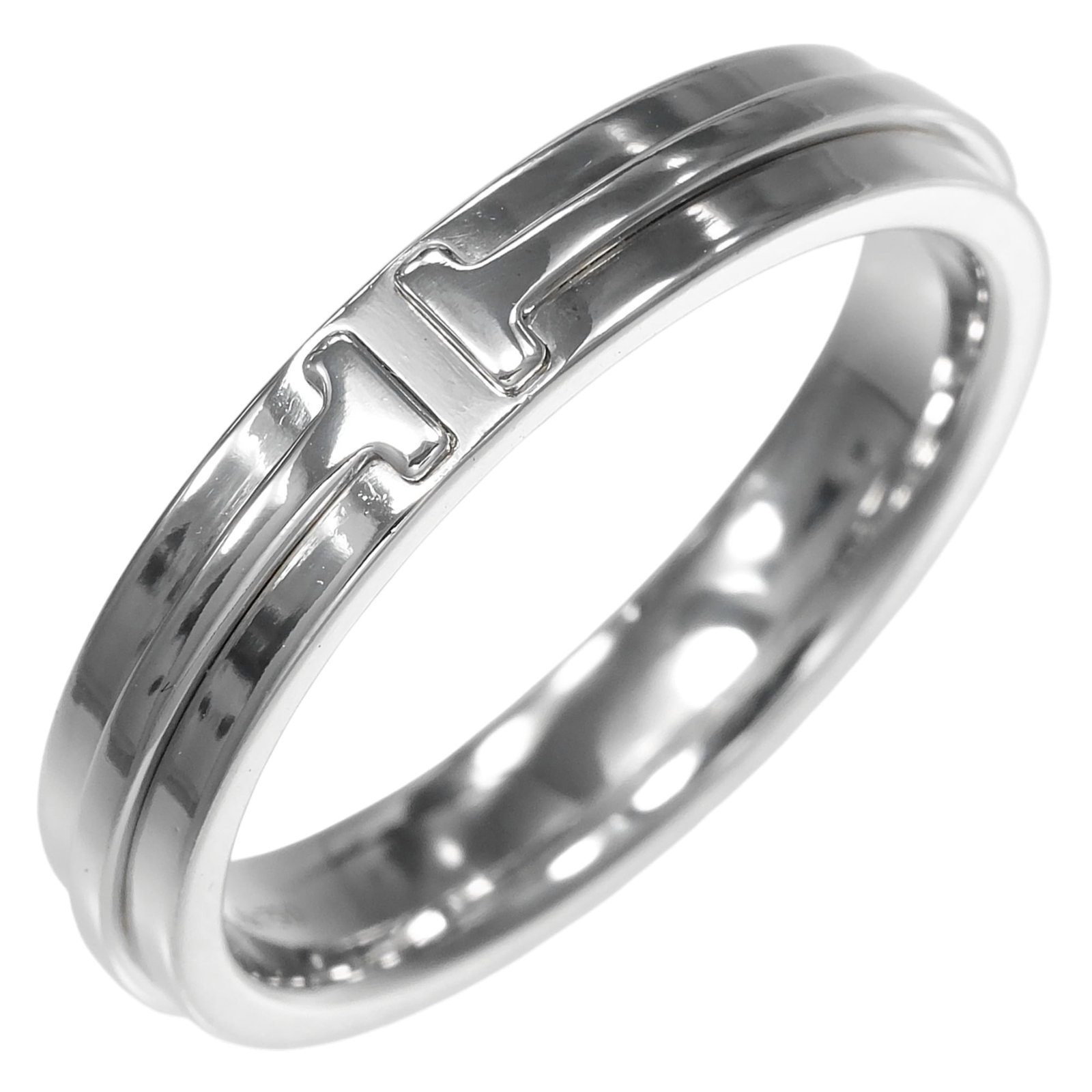 Tiffany Band Ring White Gold (18K): Tiffany Band Ring White Gold (18K) This Tiffany band ring in white gold (18K) features a sleek design with a silver tone. It has been worn and shows some signs of usage, including scratches and minor 