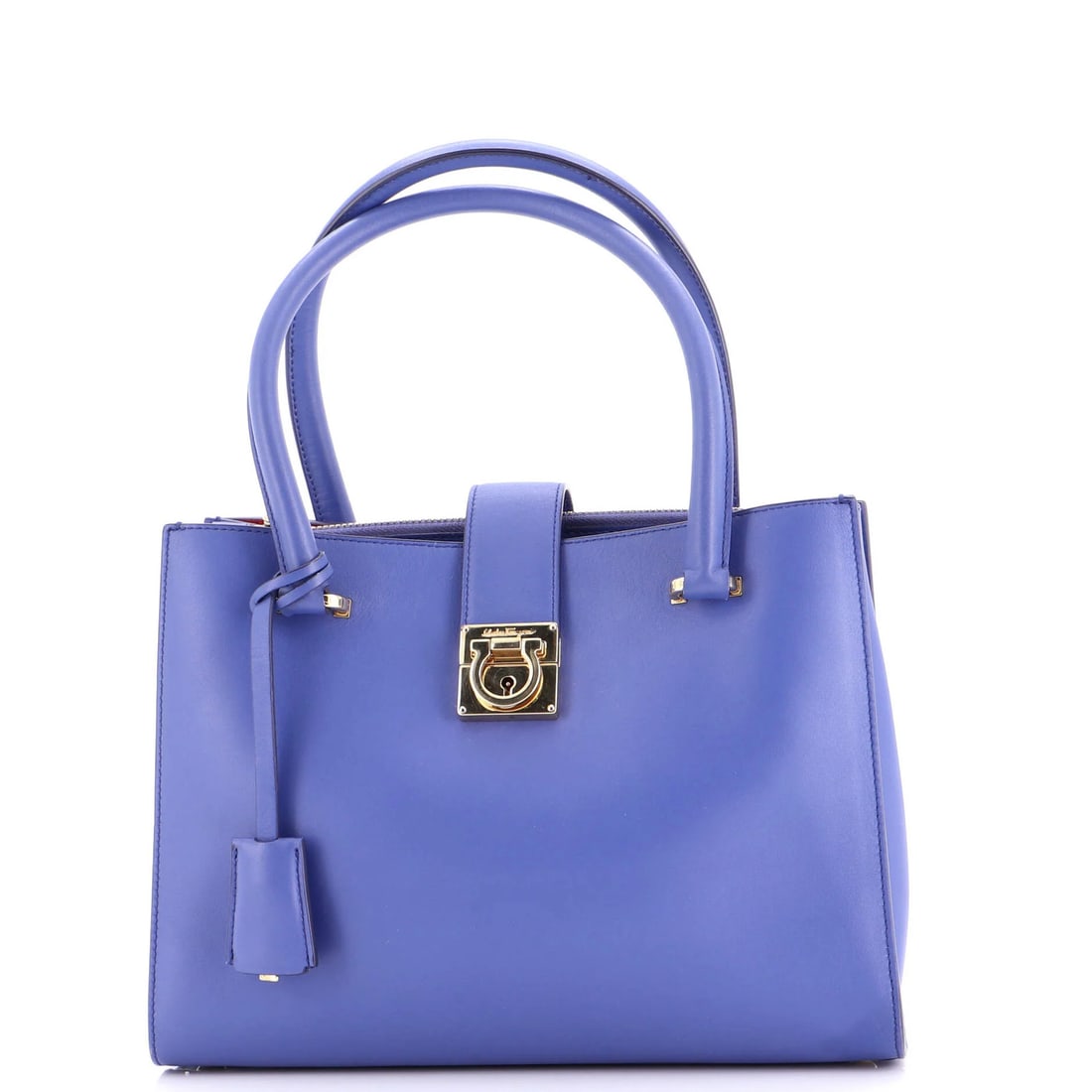 Small leather lock tote by Salvatore Ferragamo Gancio: Small leather lock tote by Salvatore Ferragamo Gancio Small leather lock tote by Salvatore Ferragamo Gancio features a classic blue exterior with gold hardware and a striking red interior. The item bo