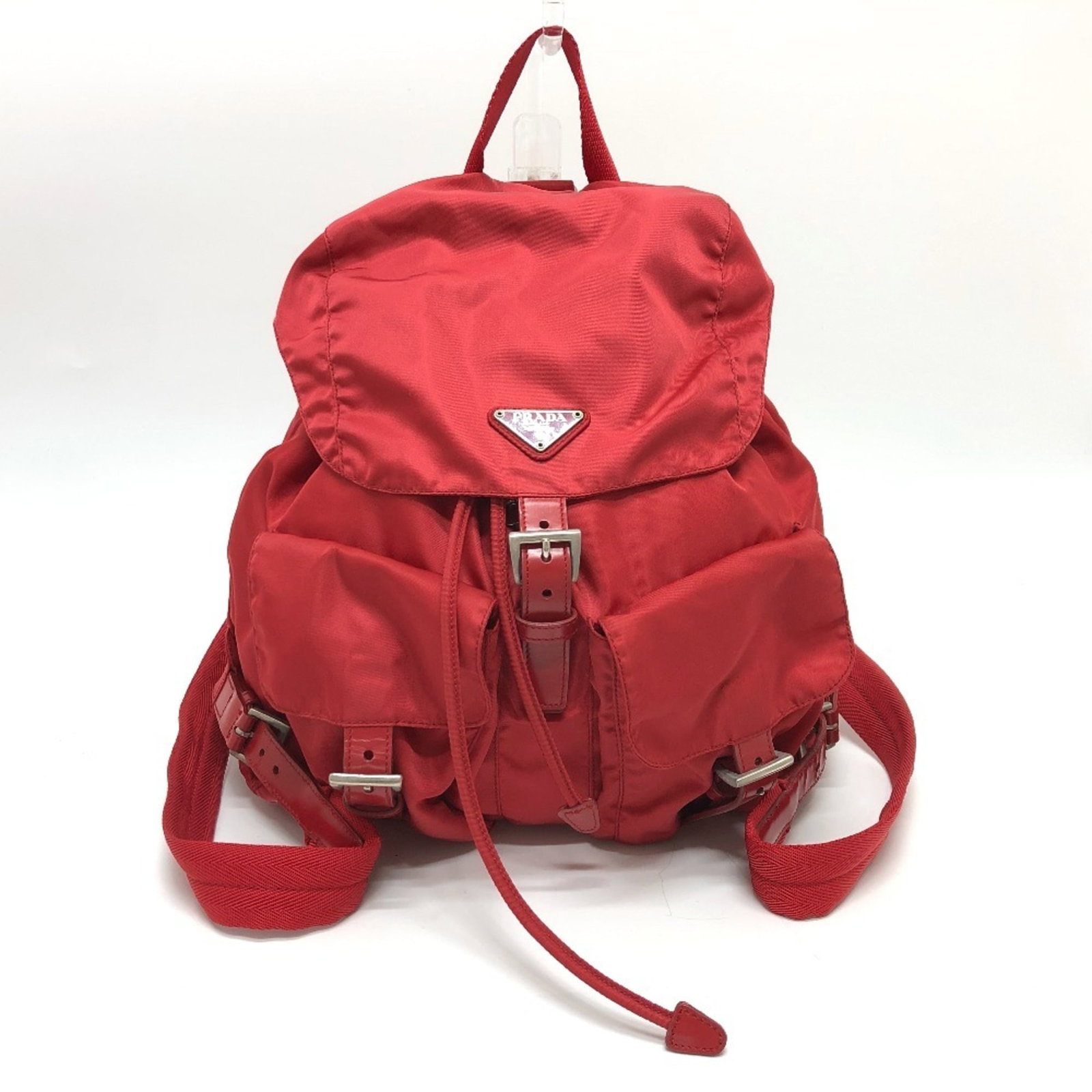 Prada Backpack Nylon: Prada Backpack Nylon The Prada Backpack Nylon in red features a sleek and durable design with silver hardware. With its classic nylon material and spacious interior, this backpack has been well-loved