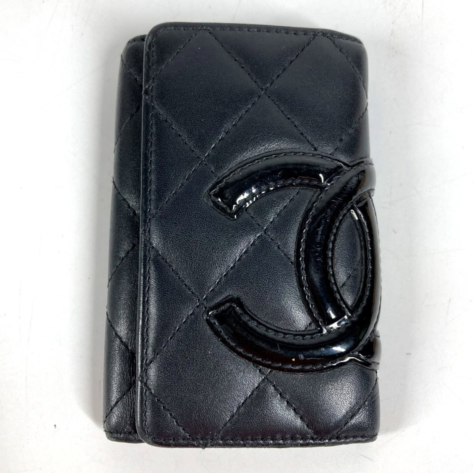 Chanel Keycase Leather: Chanel Keycase Leather This black Chanel Keycase Leather features six key hooks and has been used, with traces of usage and minor damages visible. The leather remains in acceptable condition for conti