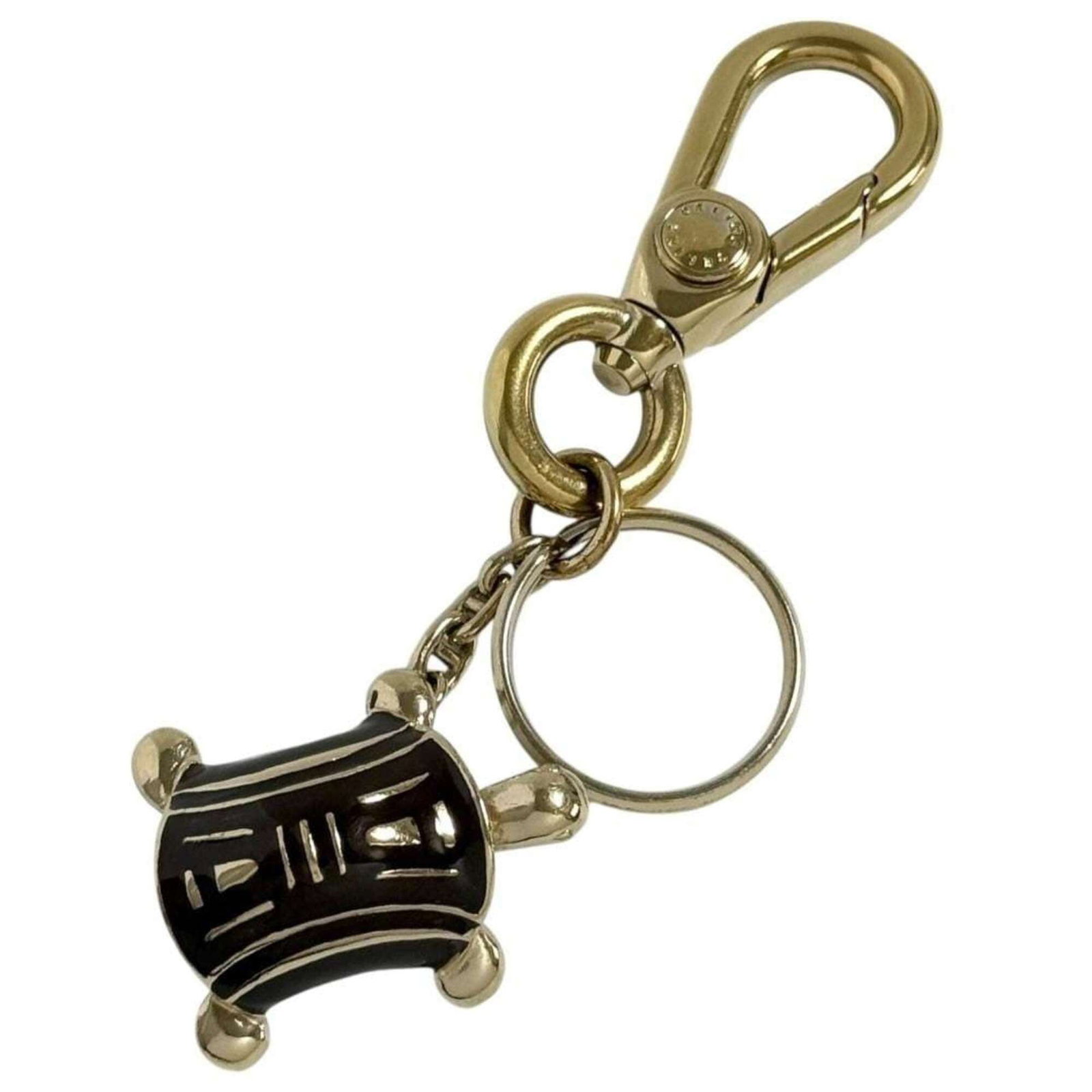 Celine Keyring Metal: Celine Keyring Metal Celine Keyring Metal has a distinctive brown metal finish and shows signs of being used, with visible scratches and dirt. The keyring itself appears to be in good condition