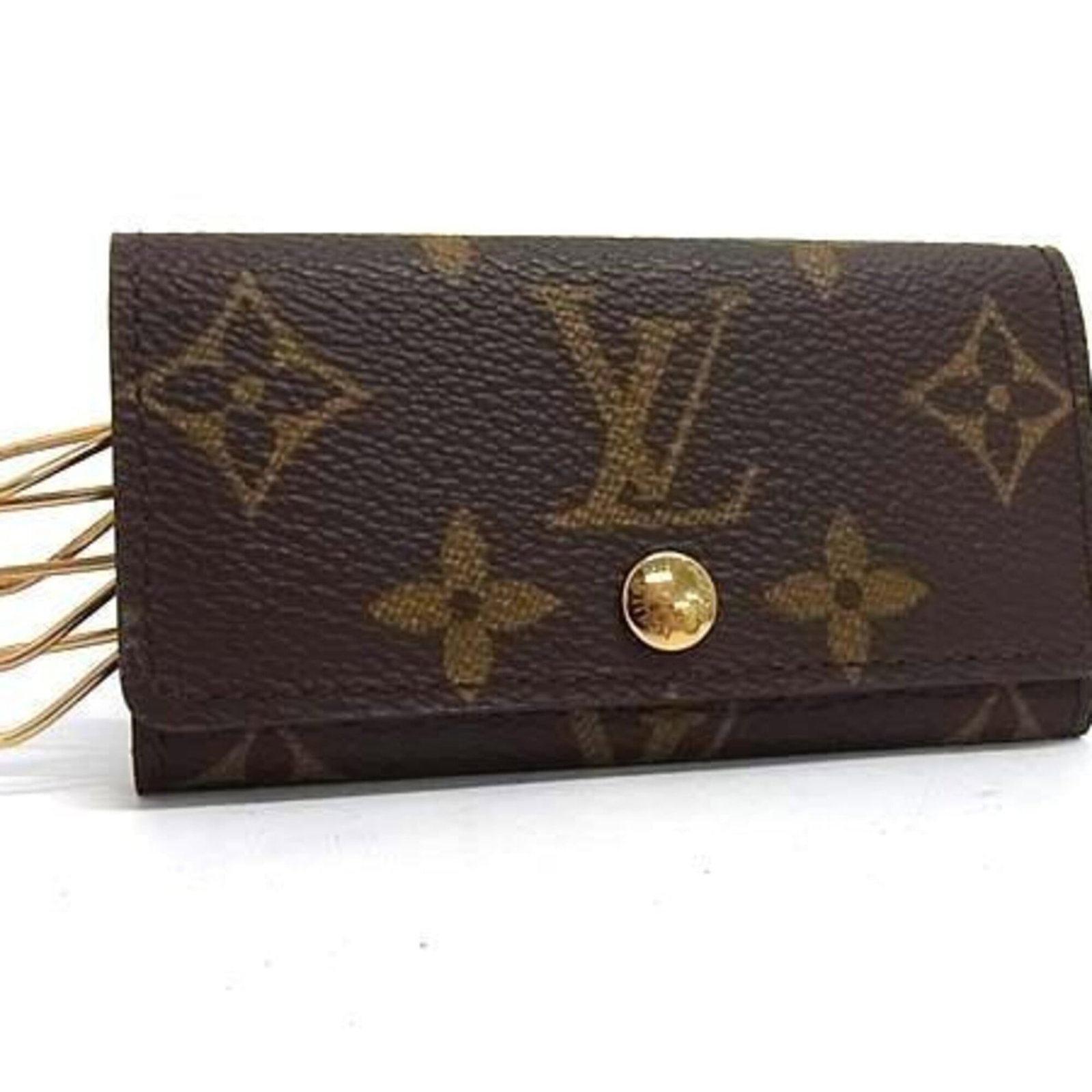 Louis Vuitton Keycase Monogram: Louis Vuitton Keycase Monogram Monogrammed with iconic Louis Vuitton style, this brown Keycase features a few traces of usage and minor scratches/dirt. Despite showing signs of wear, the condition