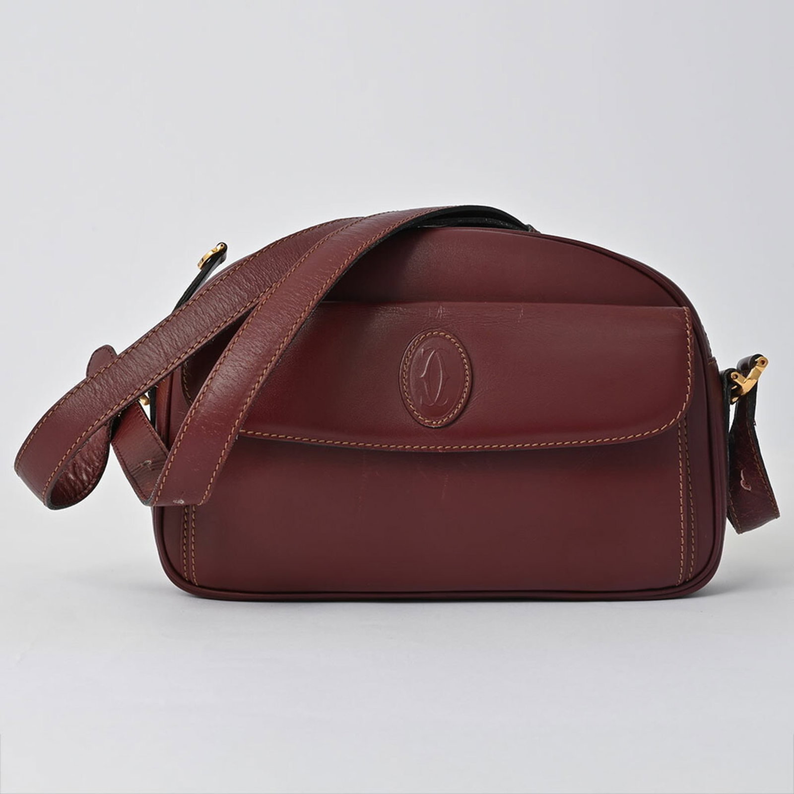 Cartier Shoulder Bag Leather: Cartier Shoulder Bag Leather Cartier's iconic shoulder bag boasts a rich Bordeaux leather exterior with subtle scratches and signs of gentle wear. This pre-owned piece features a sturdy zipper closure