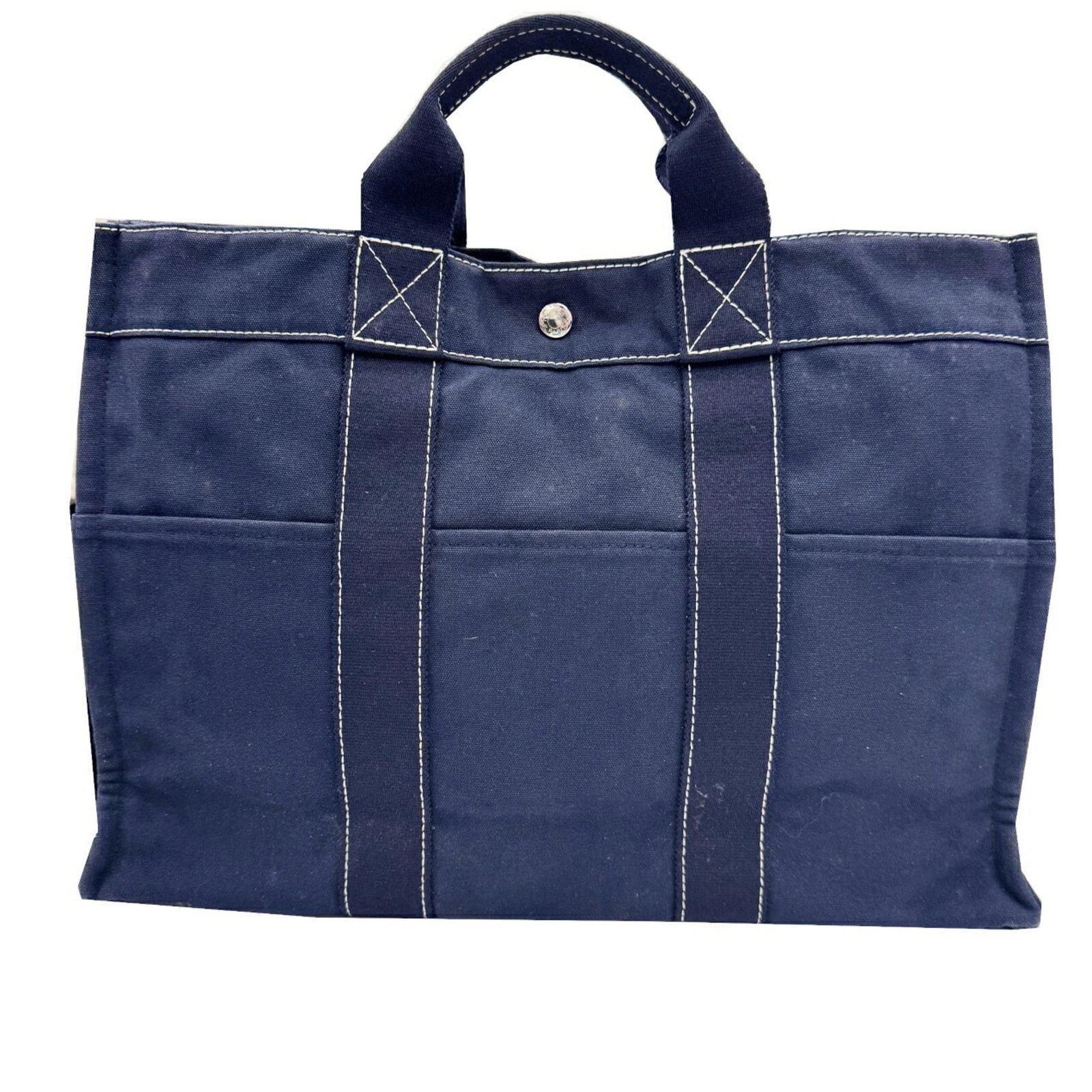 Hermes Handbag Canvas: Hermes Handbag Canvas Navy canvas handbag from Hermes with a classic design and timeless appeal. Measuring 31cm x 42.5cm x 10cm, this used bag features traces of usage and minor scratches/dirt, giving
