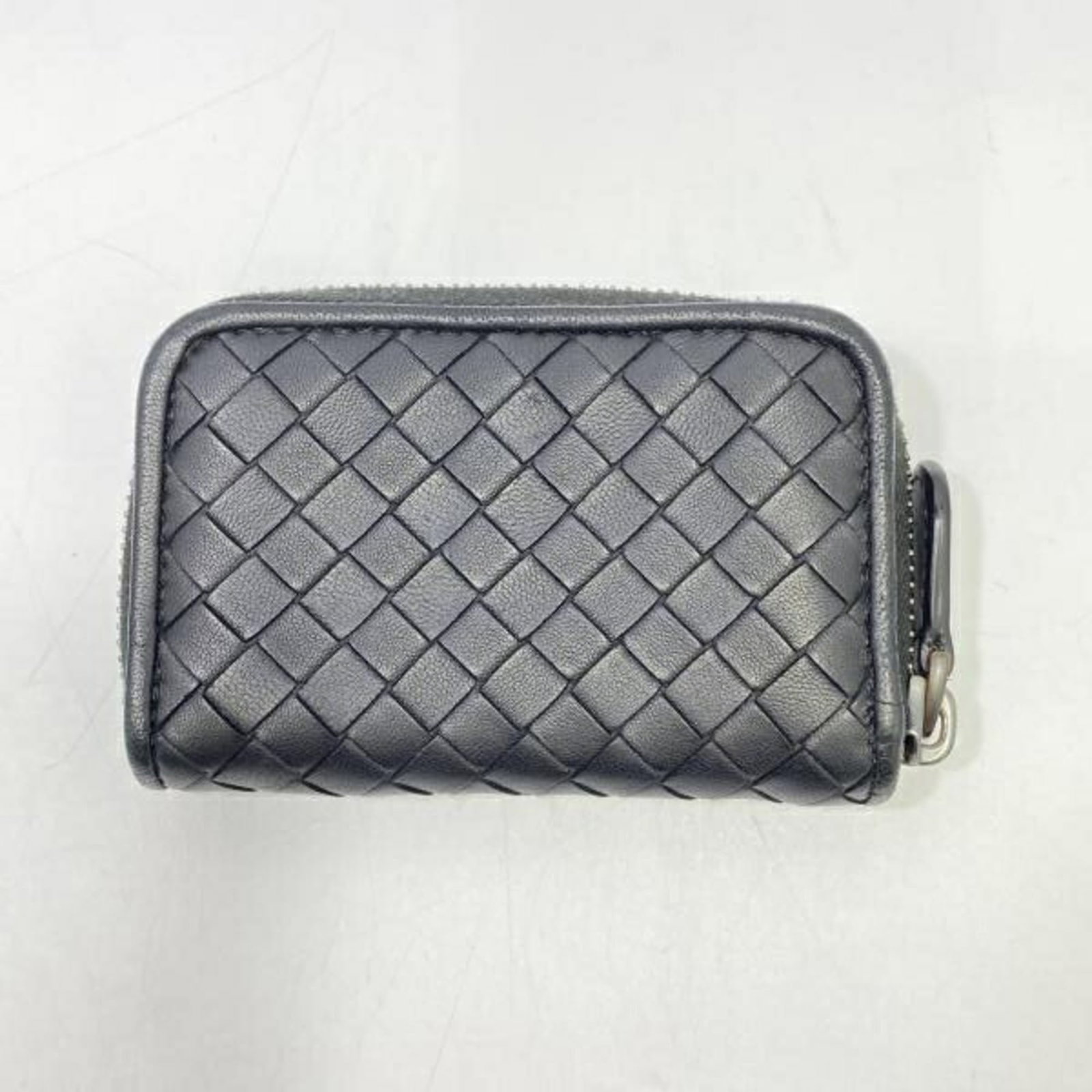 Bottega Veneta Coin Purse/Coin Case Intrecciato: Bottega Veneta Coin Purse/Coin Case Intrecciato The Bottega Veneta Coin Purse/Coin Case Intrecciato boasts its iconic Intrecciato weave in sleek black and blue hues. With a compact size and durable co
