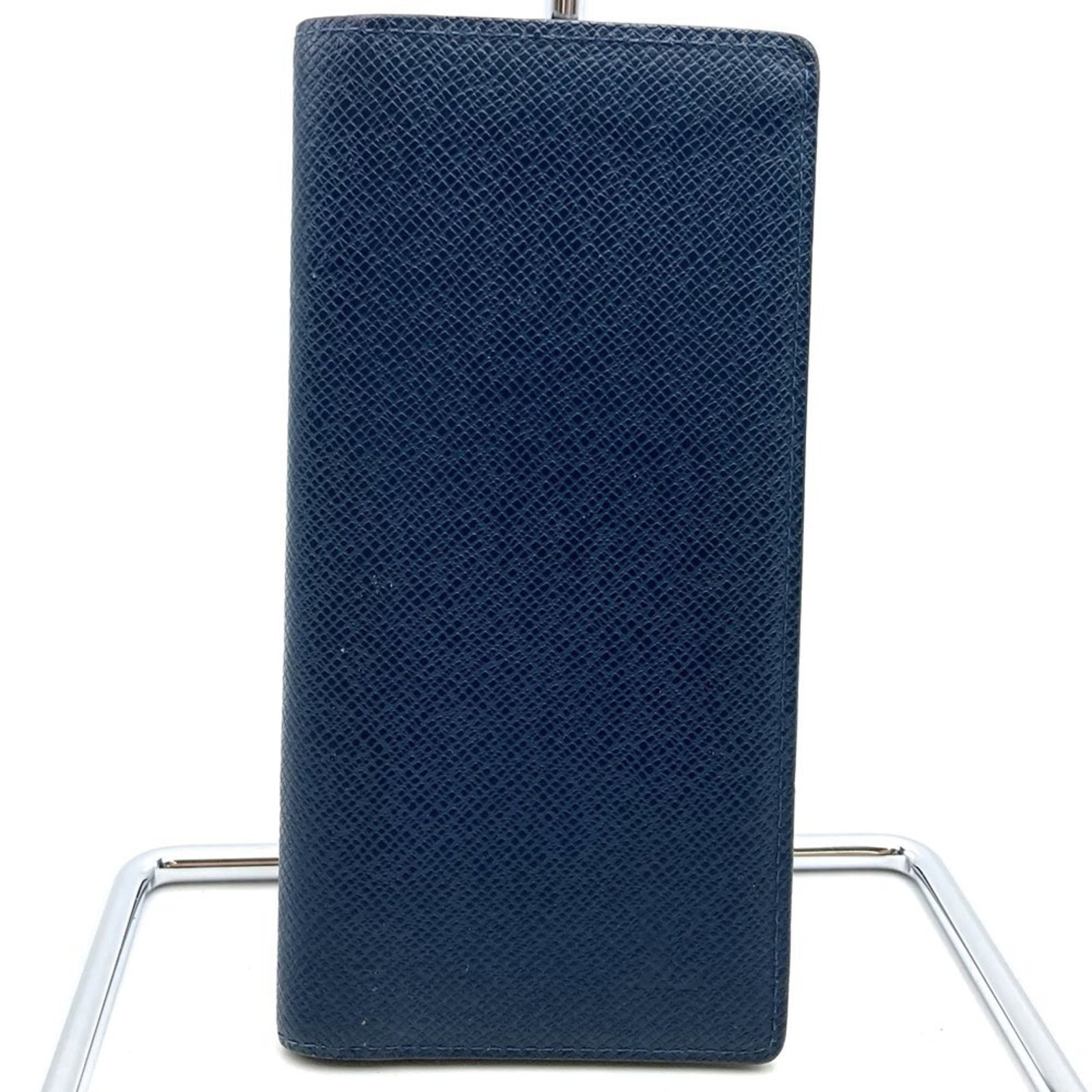 Louis Vuitton Long Wallet (Bi-Fold) Taiga Leather: Louis Vuitton Long Wallet (Bi-Fold) Taiga Leather Taiga leather gives this bi-fold long wallet a rugged touch. With its navy color and functional design, it features multiple pockets for cards, coins,