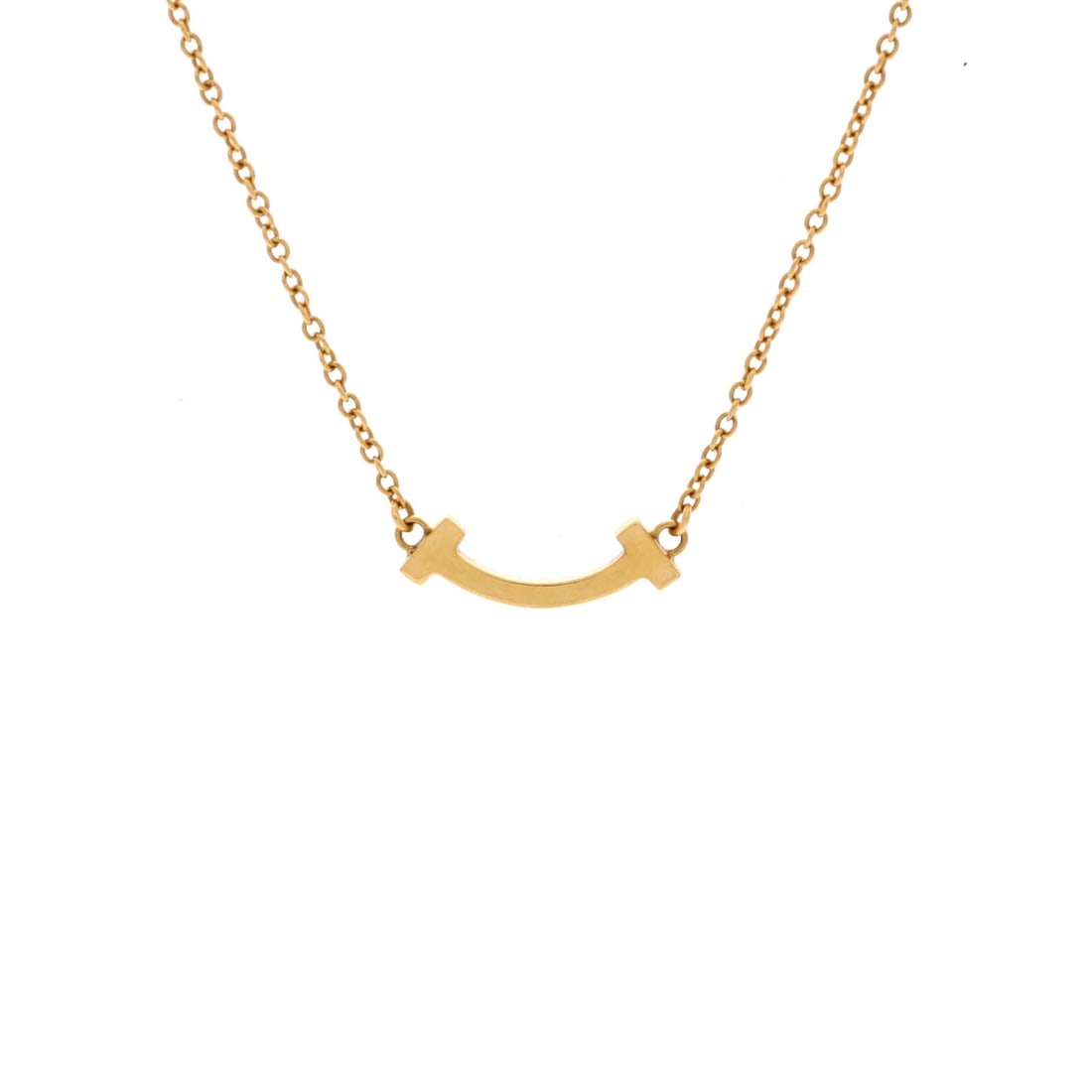 STRICT YELLOW GOLD PENDANT NECKLACE T SMILE TIFANY CO: STRICT YELLOW GOLD PENDANT NECKLACE T SMILE TIFANY CO Tiffany & Co.'s T Smile Pendant Necklace is a delicate yet elegant piece featuring a 4.50 mm yellow gold pendant on an adjustable chain. The 18K