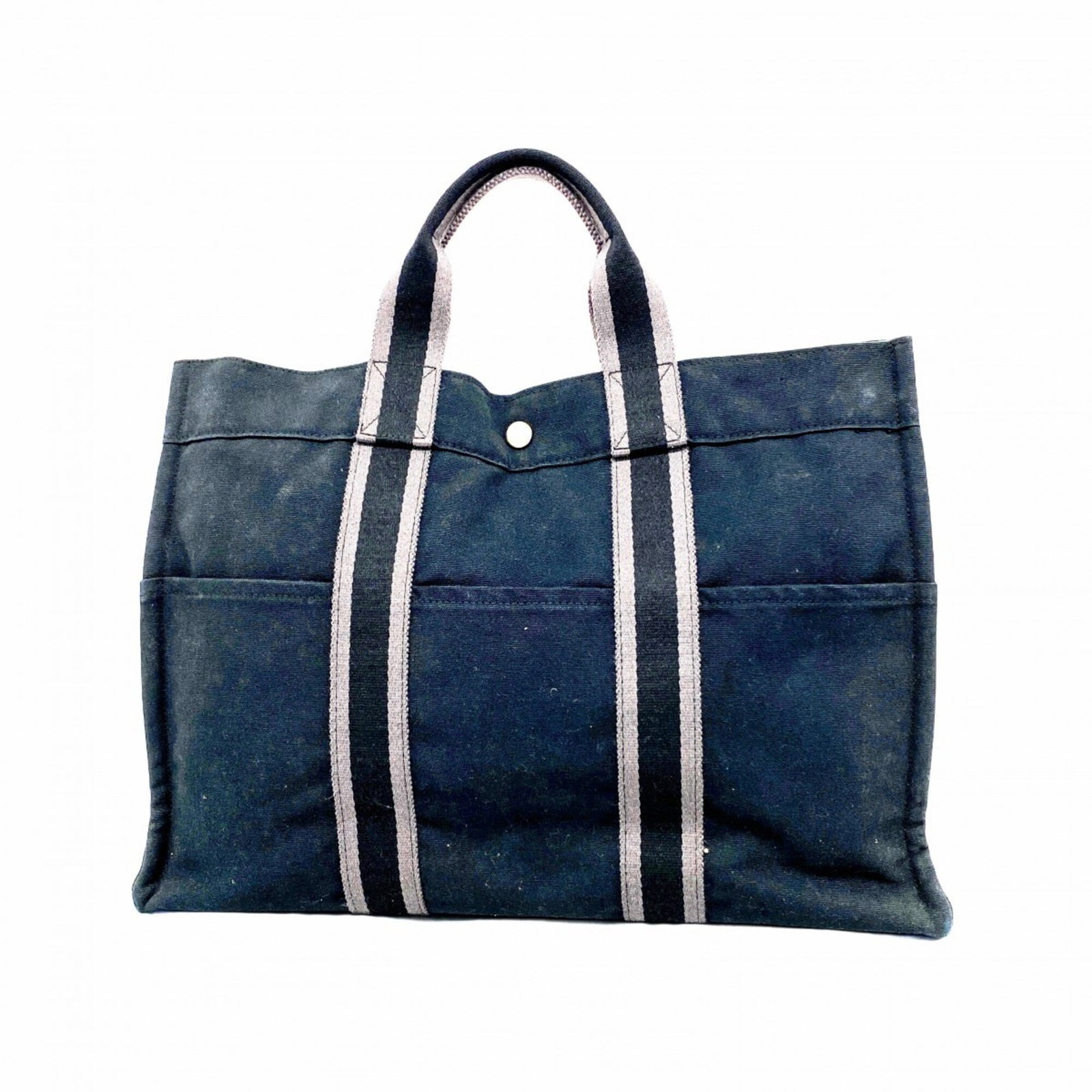 Hermes Tote Bag Canvas: Hermes Tote Bag Canvas Canvas tote bag from Hermes in black with silver hardware. The bag features a classic design and has been used, showing traces of usage with scratches and dirt. Its condition is
