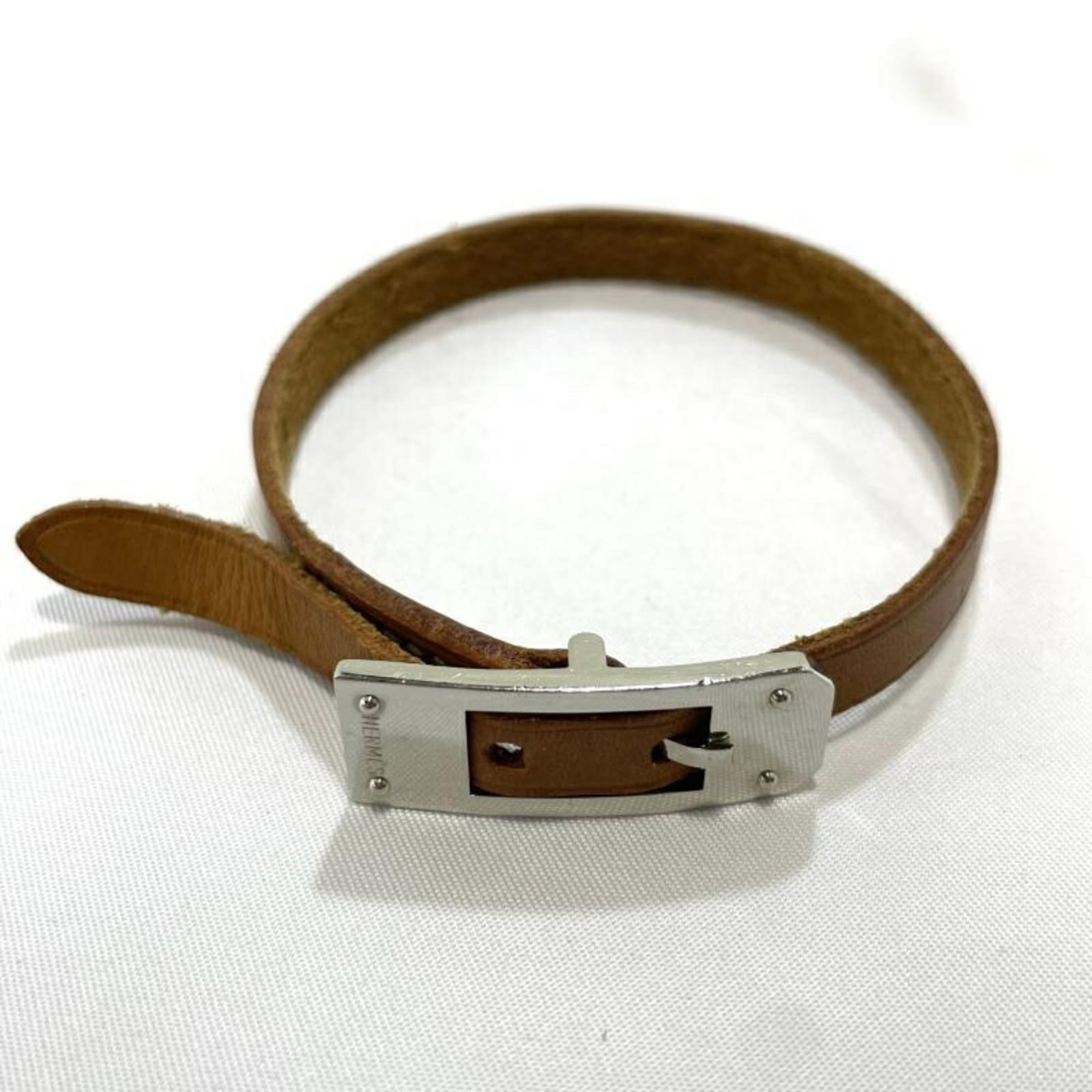Hermes Charm Bracelet: Hermes Charm Bracelet The Hermes Charm Bracelet boasts a rich brown hue and a length of 21cm, making it a stylish accessory for any wrist. With its used condition featuring traces of usage and minor s