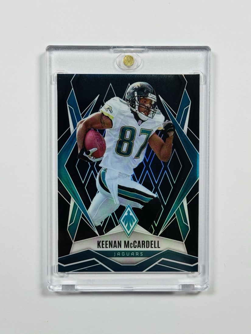 BLACK PHOENICKEE McCARDELL KEENAN PANINIPHONE: BLACK PHOENICKEE McCARDELL KEENAN PANINIPHONE Keenan McCardell's autographed card features his image and signature on standard league NFL football trading cards. The item is part of the 2025 Panini Ph