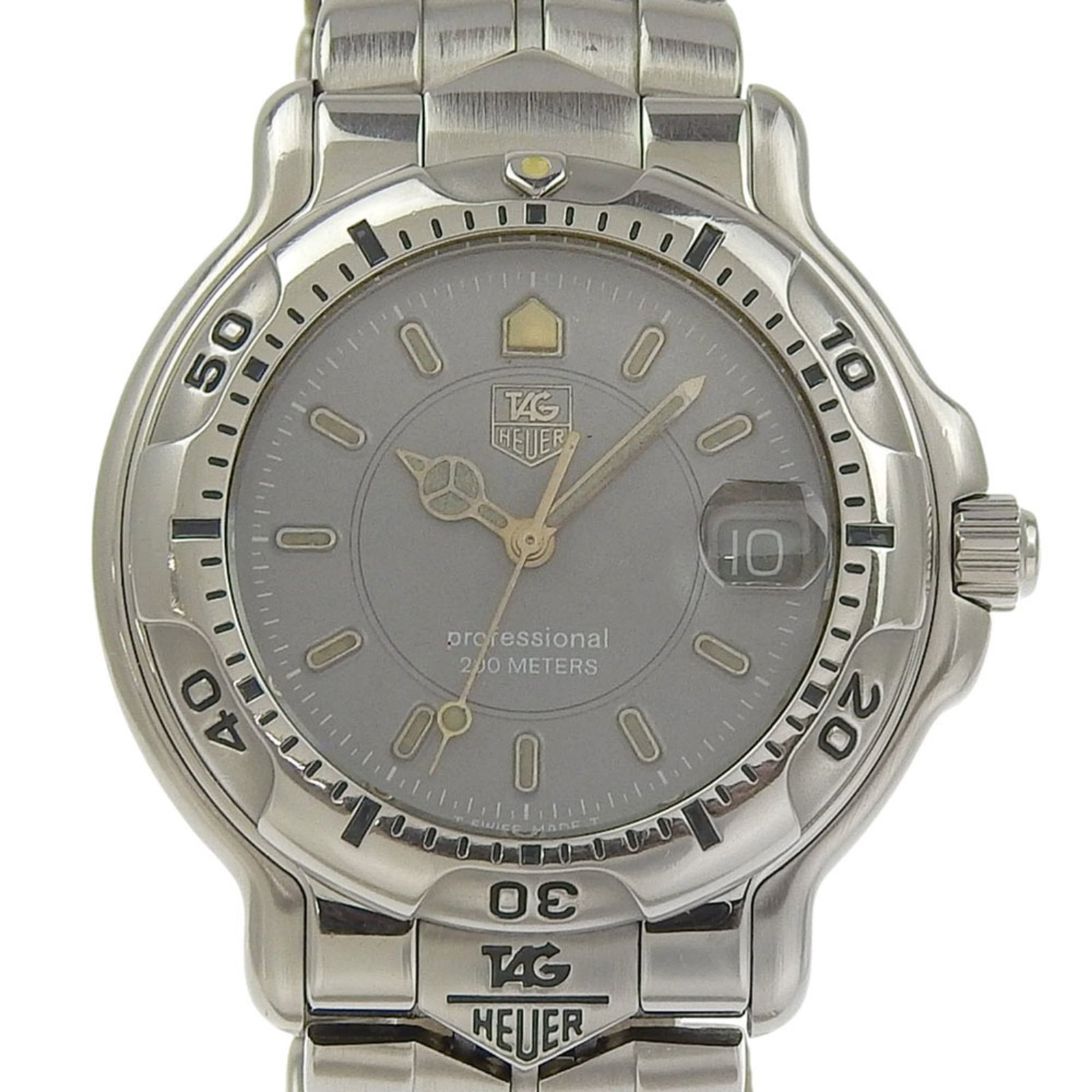 Heuer Watch Tag: Heuer Watch Tag Stainless steel case and band provide a durable foundation for this 43mm analog watch, featuring a gray dial. The watch has been used and shows traces of wear, with some damage and