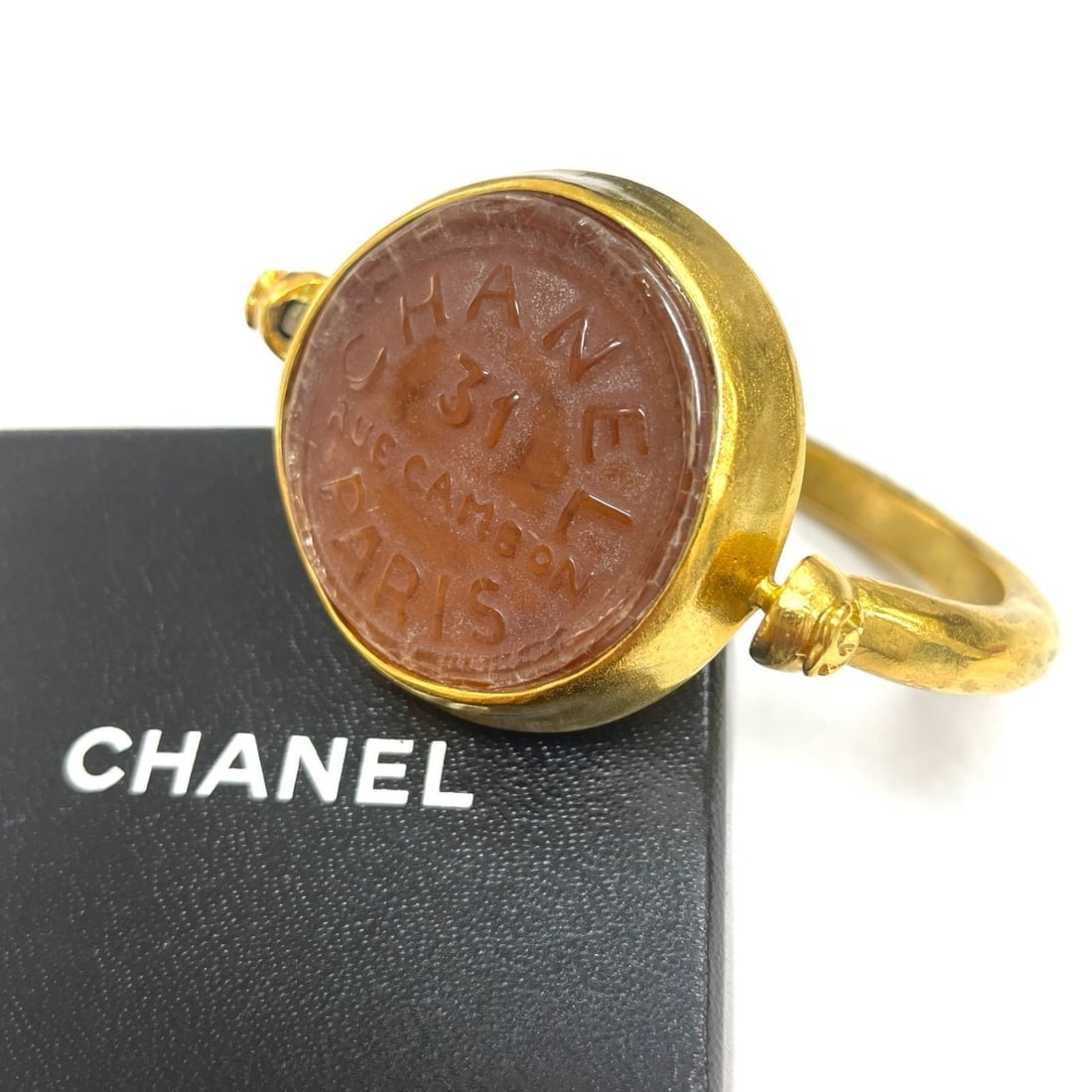 Brown Gripoix bangle 99A vintage gold Chanel: Brown Gripoix bangle 99A vintage gold Chanel Brown Gripoix bangle with round gold stone and vintage Chanel design. This 99A metal piece features a single gemstone and showcases a classic bangle style 