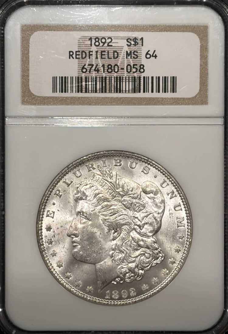 MORGAN DOLLAR REDFIELD MS64: MORGAN DOLLAR REDFIELD MS64 The Morgan Dollar Redfield MS64 features a striking silver finish and a high grade of MS64, indicating exceptional condition. Certified by NGC, this uncirculated coin