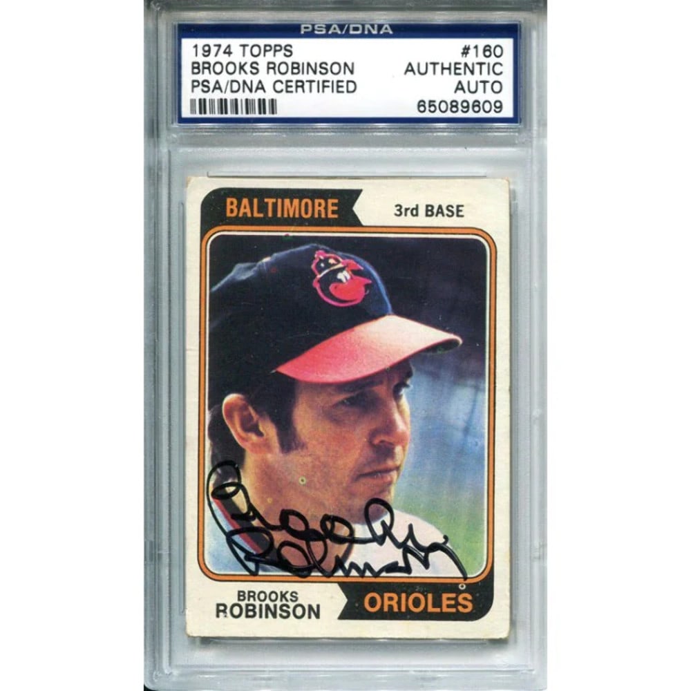 Autographed PSA Topps 1974 Card by Brooks Robinson: Autographed PSA Topps 1974 Card by Brooks Robinson Autographed PSA Topps 1974 Card by Brooks Robinson. This card features a sharpie signature across the front of the photo in black ink, bearing the