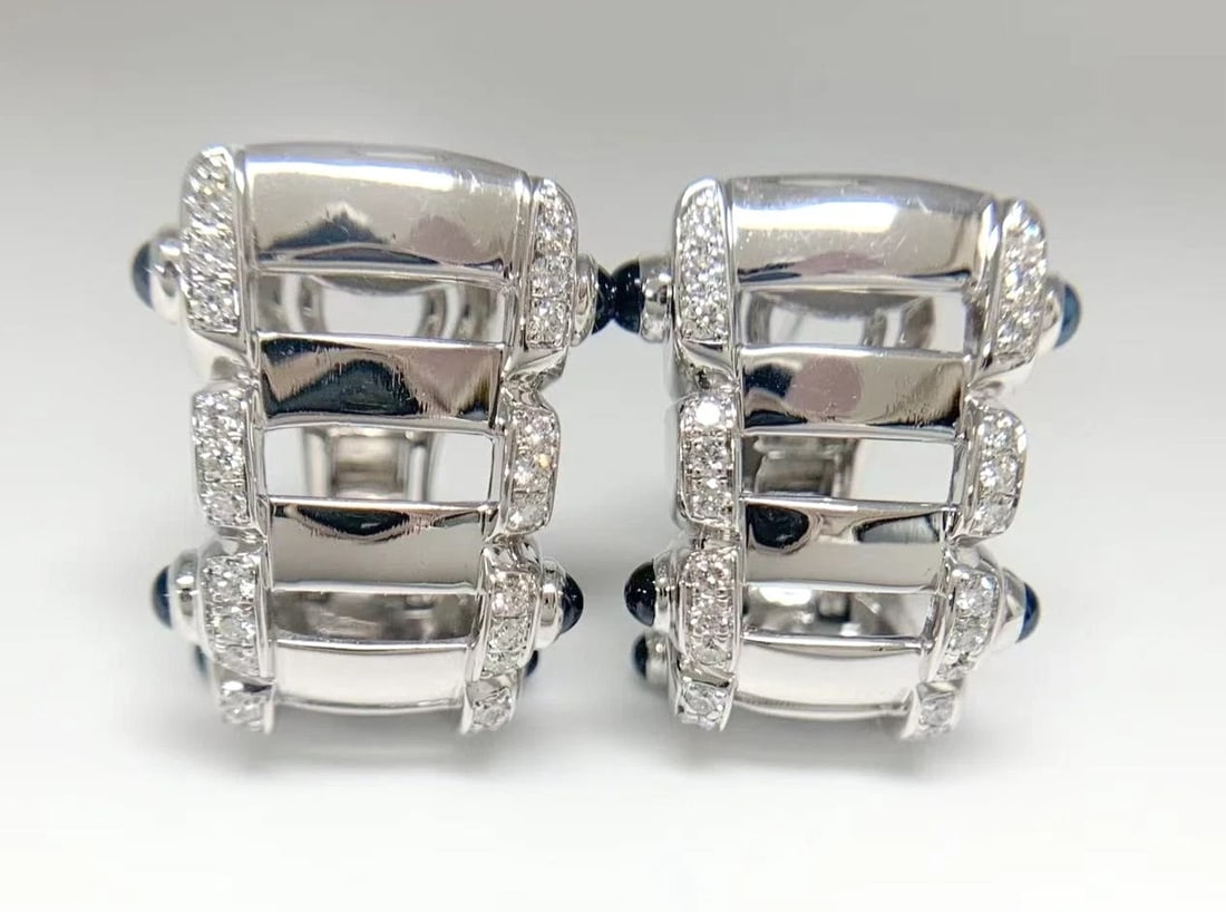 Patek Philippe Diamond and Sapphire Earrings in 18K White Gold: Patek Philippe Diamond and Sapphire Earrings in 18K White Gold 18k White Gold Earrings with Natural Sapphire and Diamond Cabochon Main Stones, Set in an Omega Back Design. The Patek Philippe earrings 
