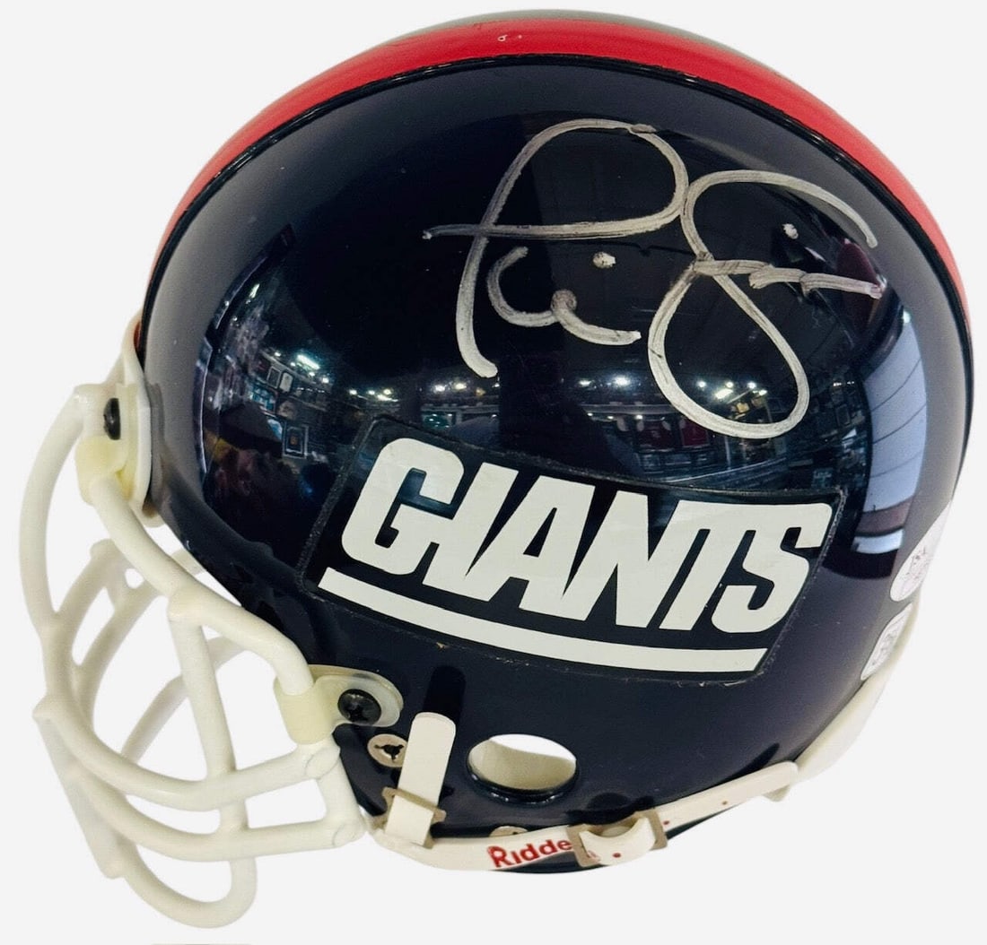 Phil Simms Autographed Giants Riddell Mini Helmet (JSA): Phil Simms Autographed Giants Riddell Mini Helmet (JSA) Signed in silver sharpie across the side of the helmet by Phil Simms, this authentic Riddell mini Giants helmet bears a unique touch from one of