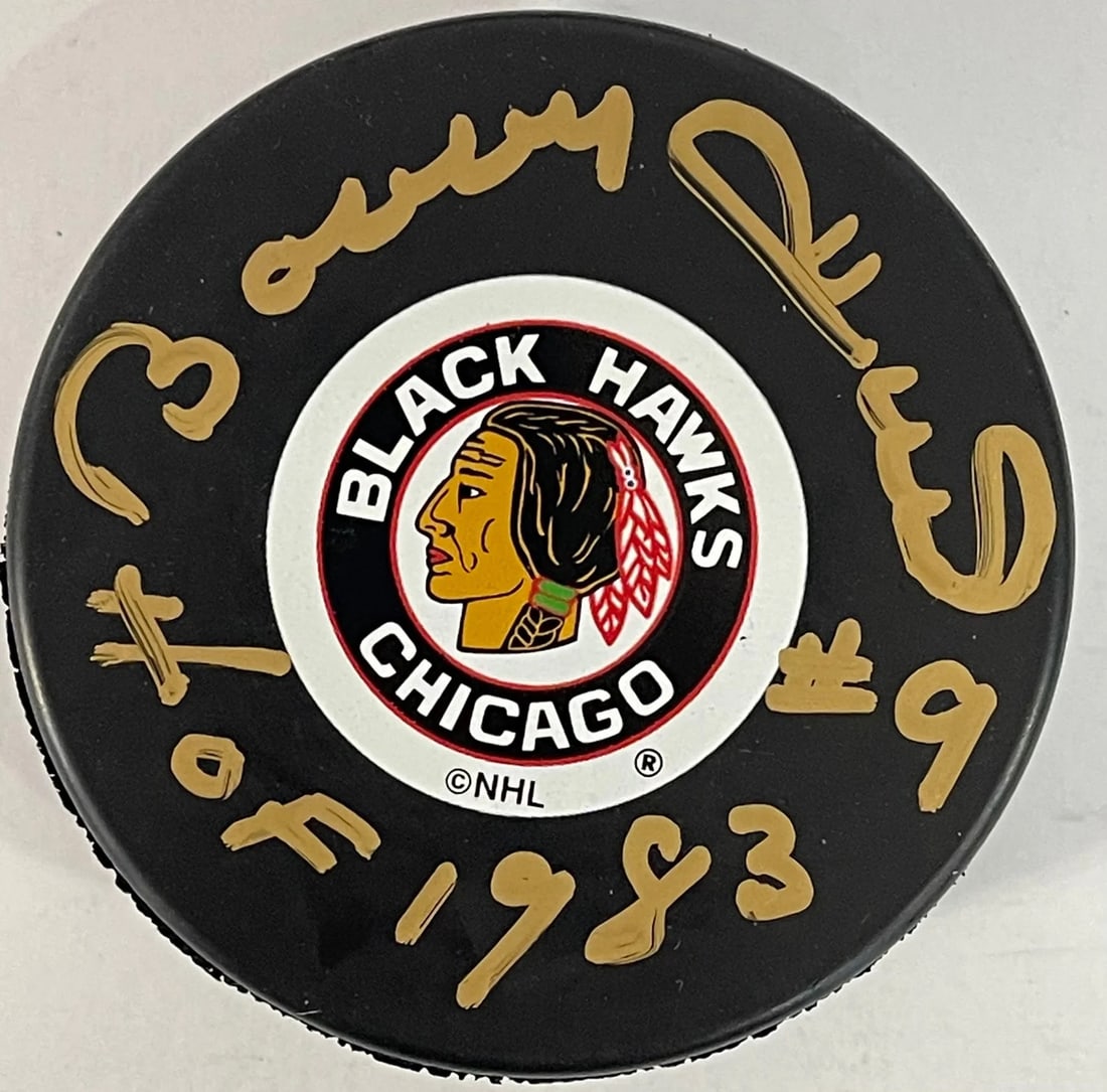 Bobby Hull official autographed Chicago Blackhawks puck: Bobby Hull official autographed Chicago Blackhawks puck Signed across the front in gold sharpie, Bobby Hull's official Chicago Blackhawks puck bears his distinctive inscription "HOF 83". This unique p