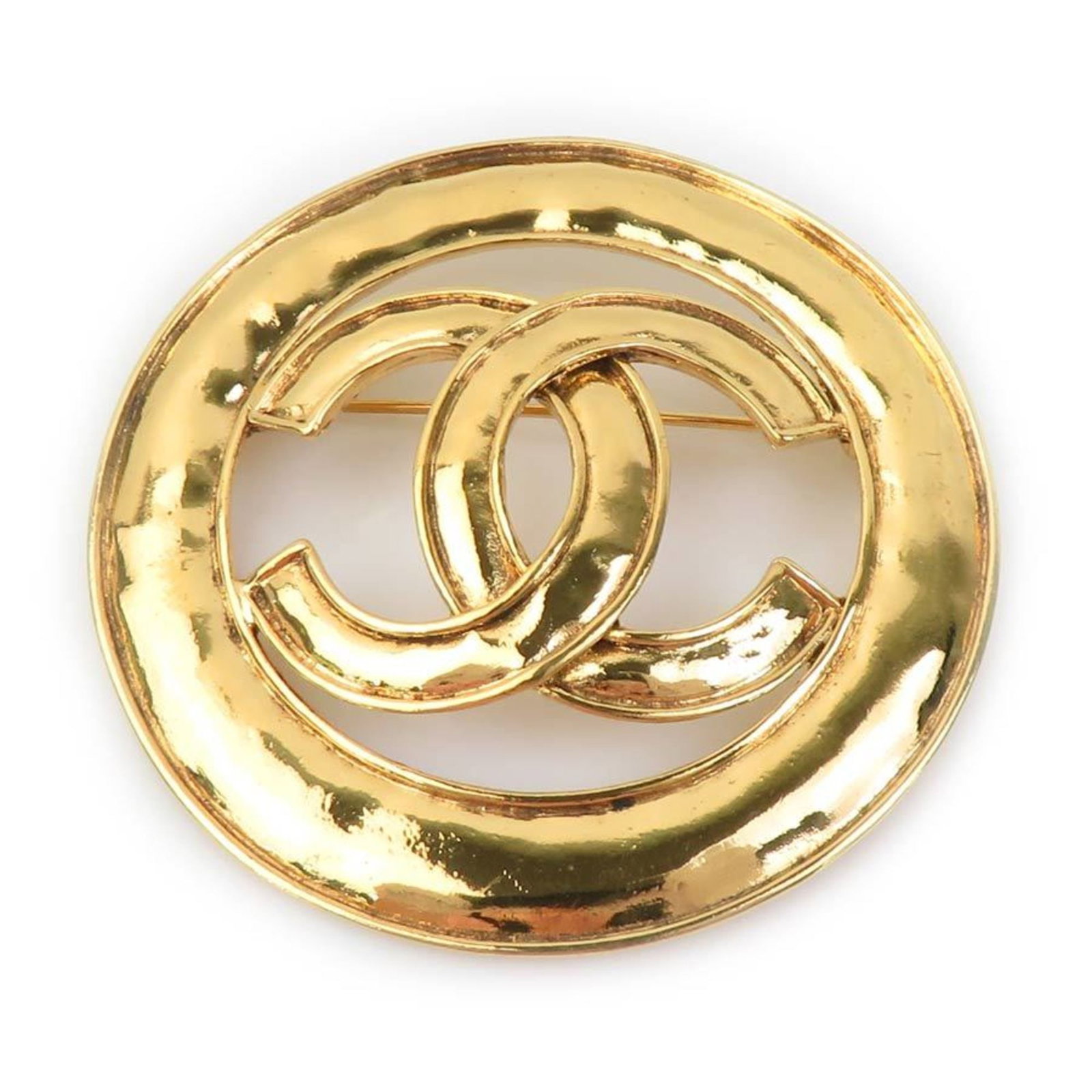 Metal brooch by Chanel: Metal brooch by Chanel Gold metal brooch by renowned fashion house Chanel, featuring a sleek design with subtle details. Measuring 6cm x 6cm, this used brooch showcases signs of wear and tear,