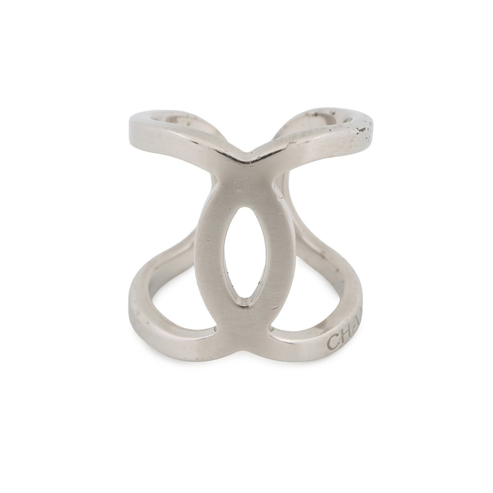 Metal Ring Chanel Band: Metal Ring Chanel Band Used Chanel band ring in metal, with a 6.5 us size and 20mm width, bearing minor traces of usage and some scratches/dirt. The ring's condition is described as very good, conside