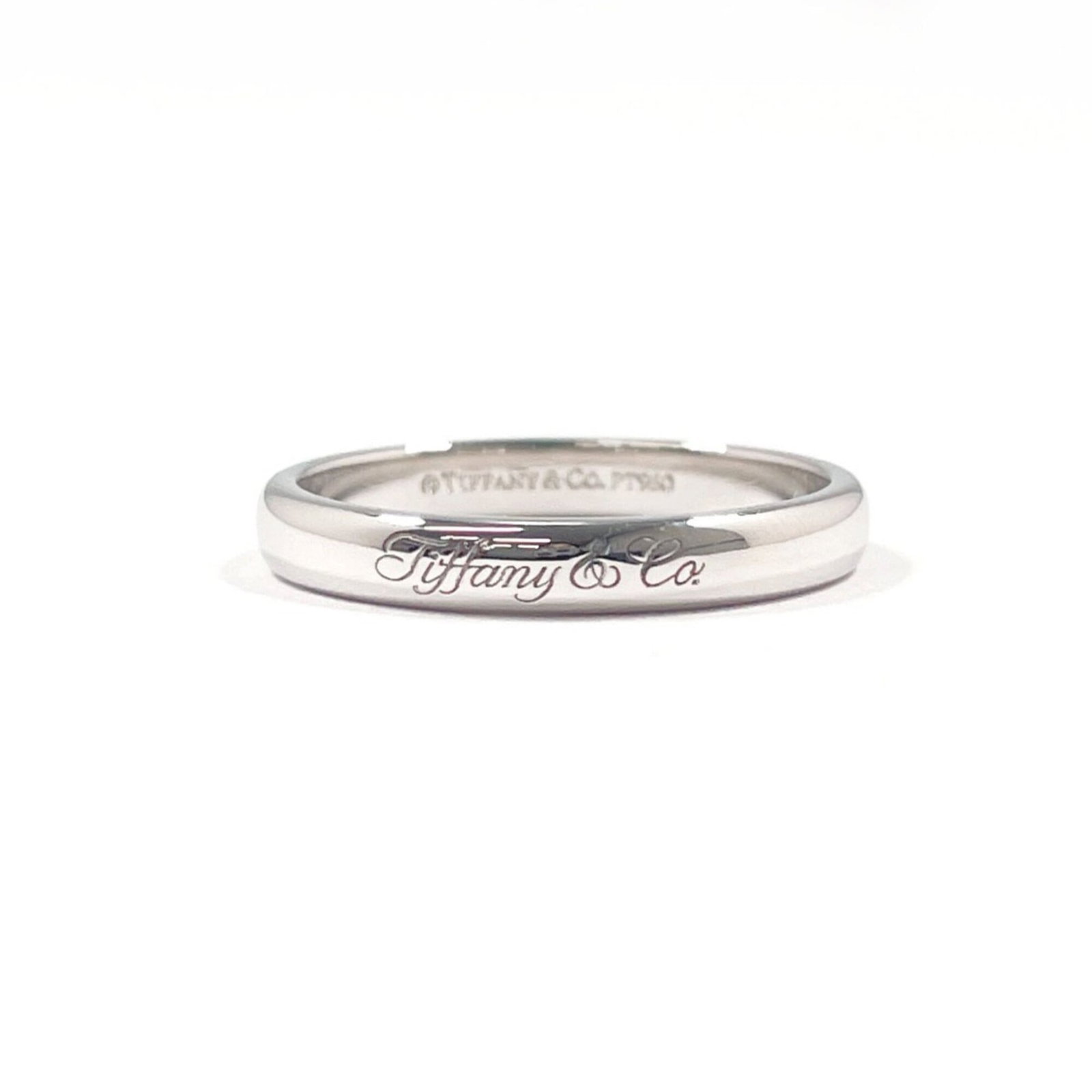 Platinum ring by Tiffany band: Platinum ring by Tiffany band This platinum band ring by Tiffany features a sleek silver design and bears the signature of its creator. With a US size of 6.5, it fits comfortably on most women's