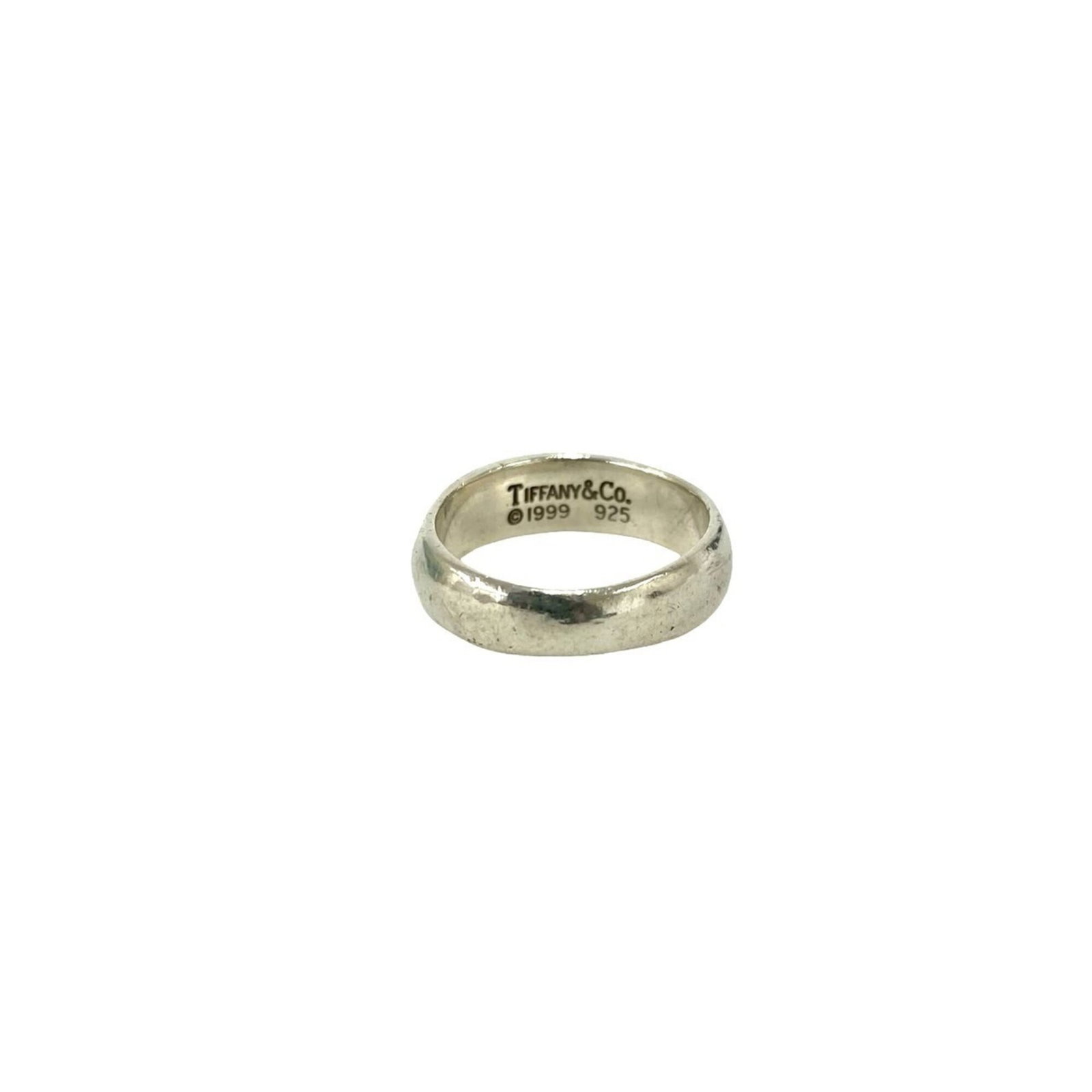 Tiffany Band Ring Silver 925: Tiffany Band Ring Silver 925 Silver band ring from Tiffany, made from sterling silver (925). The ring bears the signature of its creator and has been used, with some signs of wear visible. Overall,